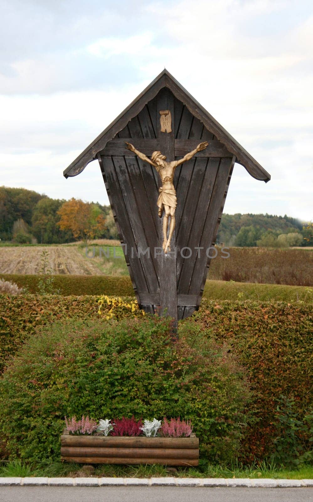 A wayside cross wooden with fields in the background