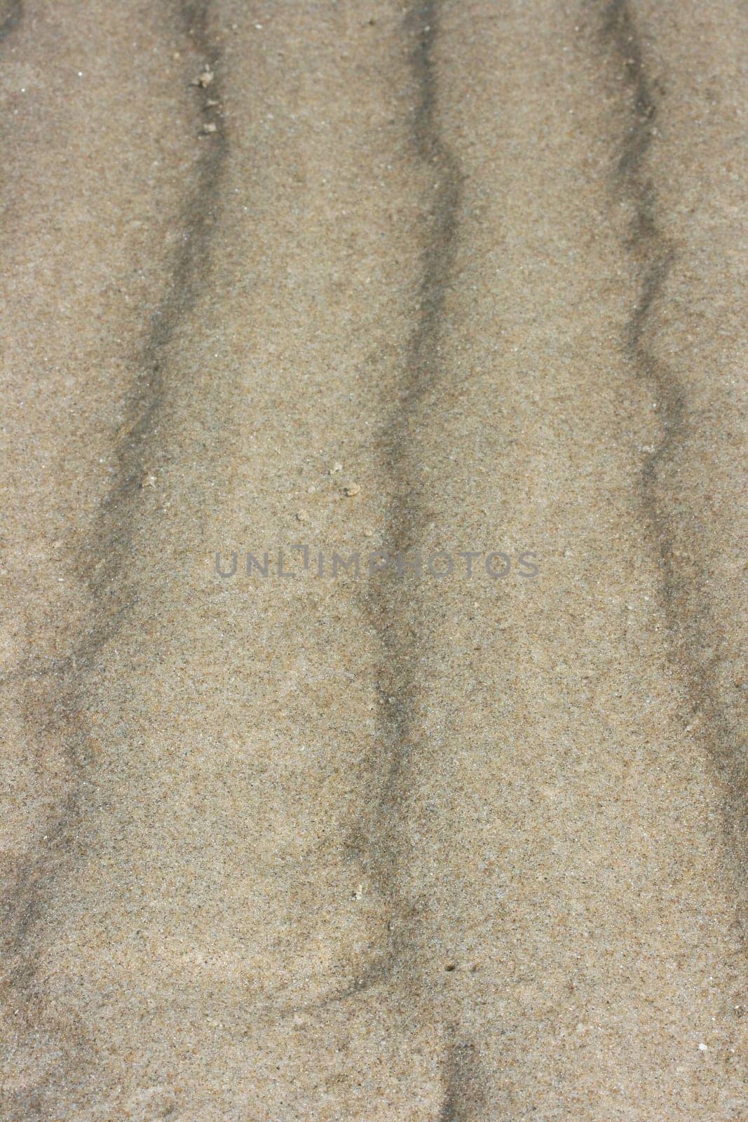 a wavy pattern in beige sand.