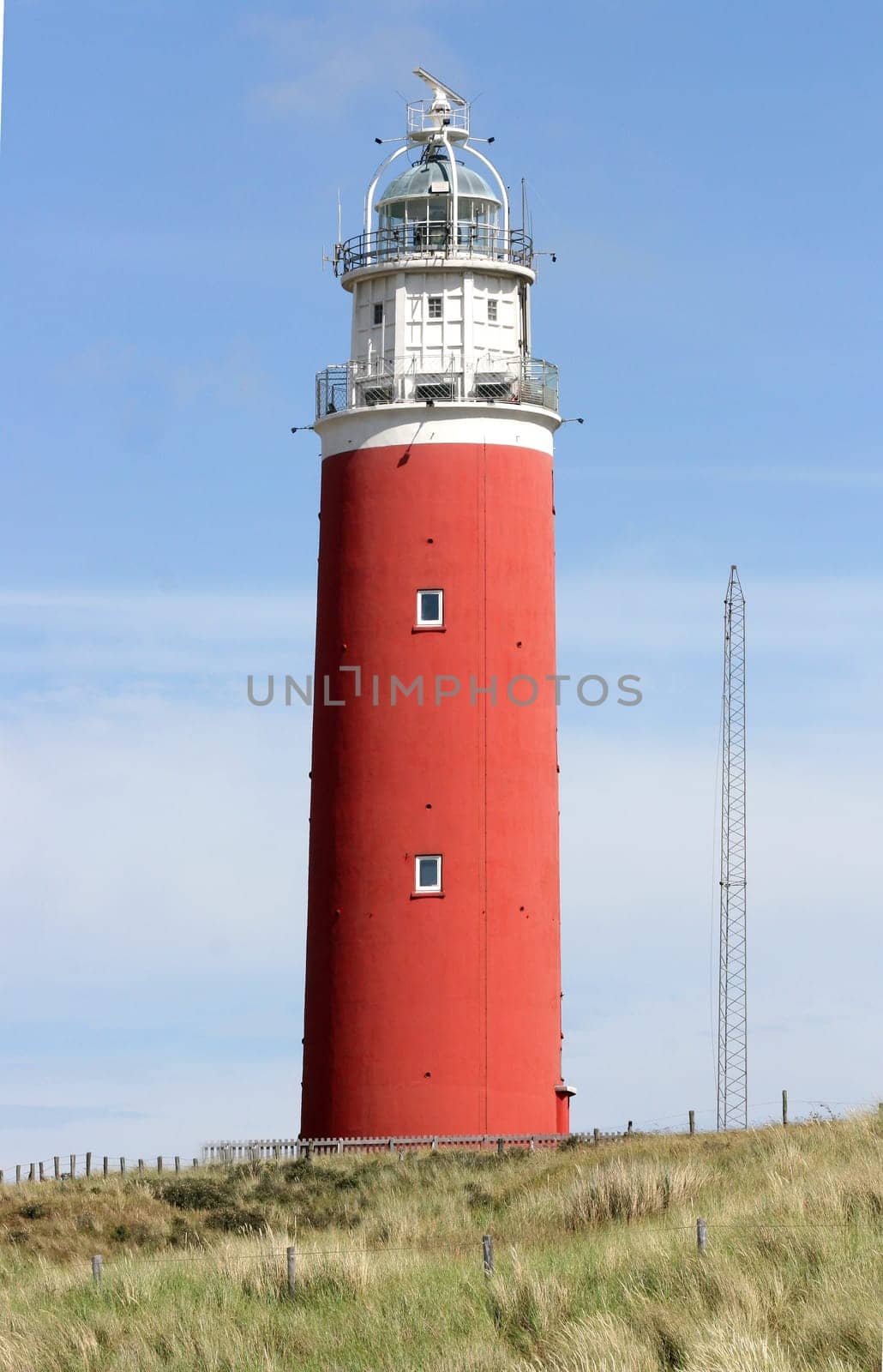 red lighthouse with blue sky in the background.