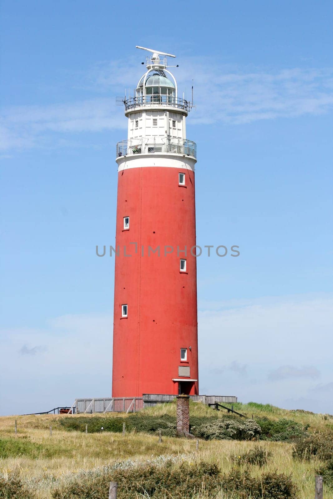 red lighthouse with blue sky in the background.