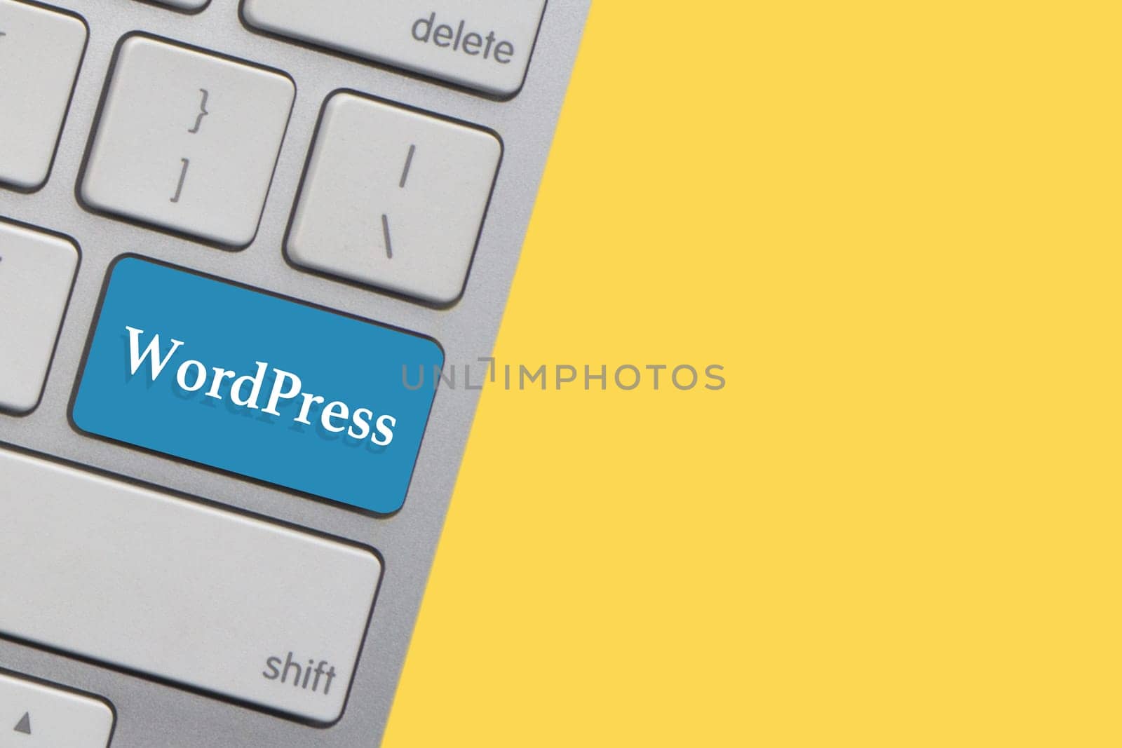 WORDPRESS text on keyboard over yellow background. Business and technology concept