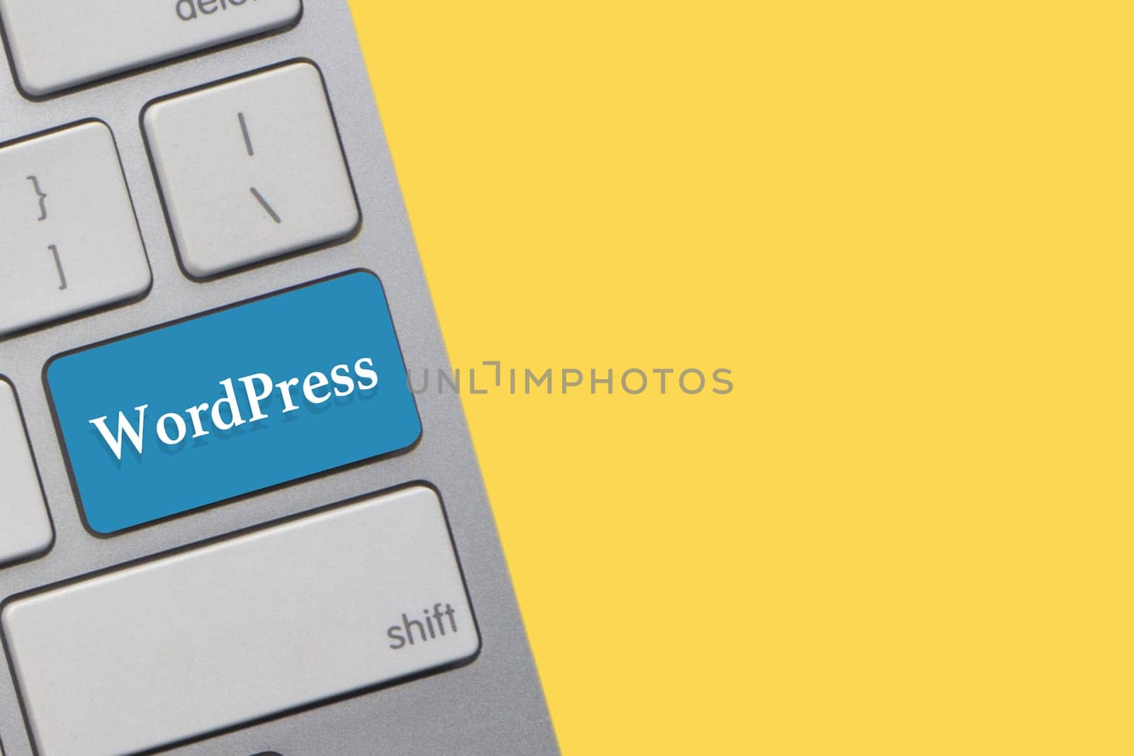 WORDPRESS text on keyboard over yellow background. Business and technology concept