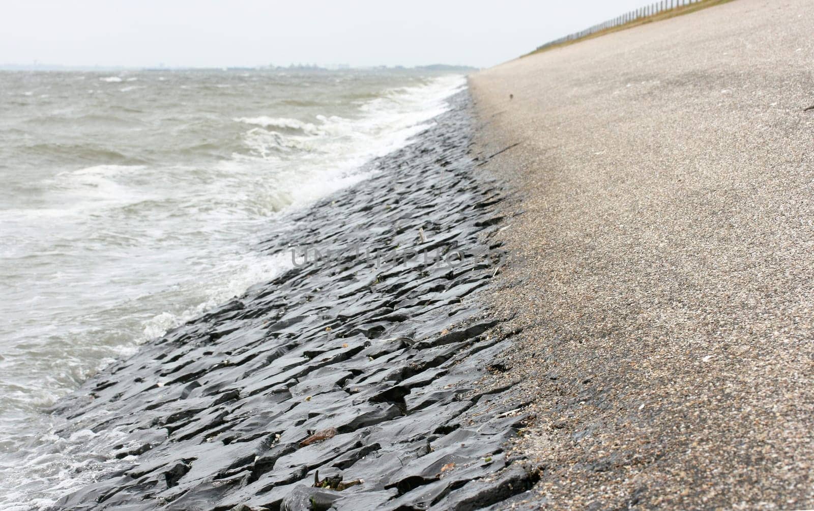 Detail view of a dam fortified with stones on the North Sea .