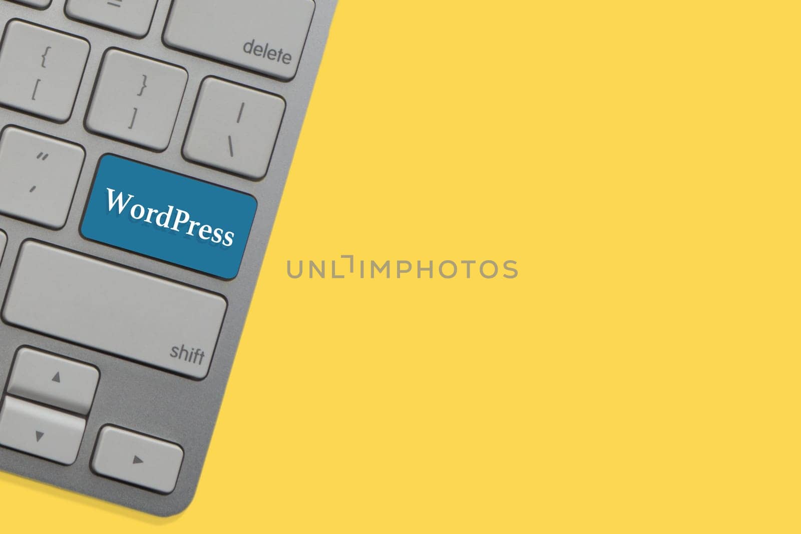WORDPRESS text on keyboard over yellow background. Business and technology concept