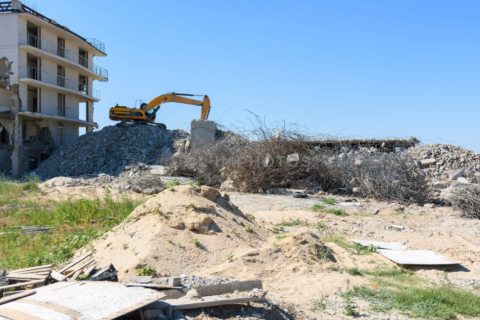 Excavator with hydraulic hammer dismantling a building