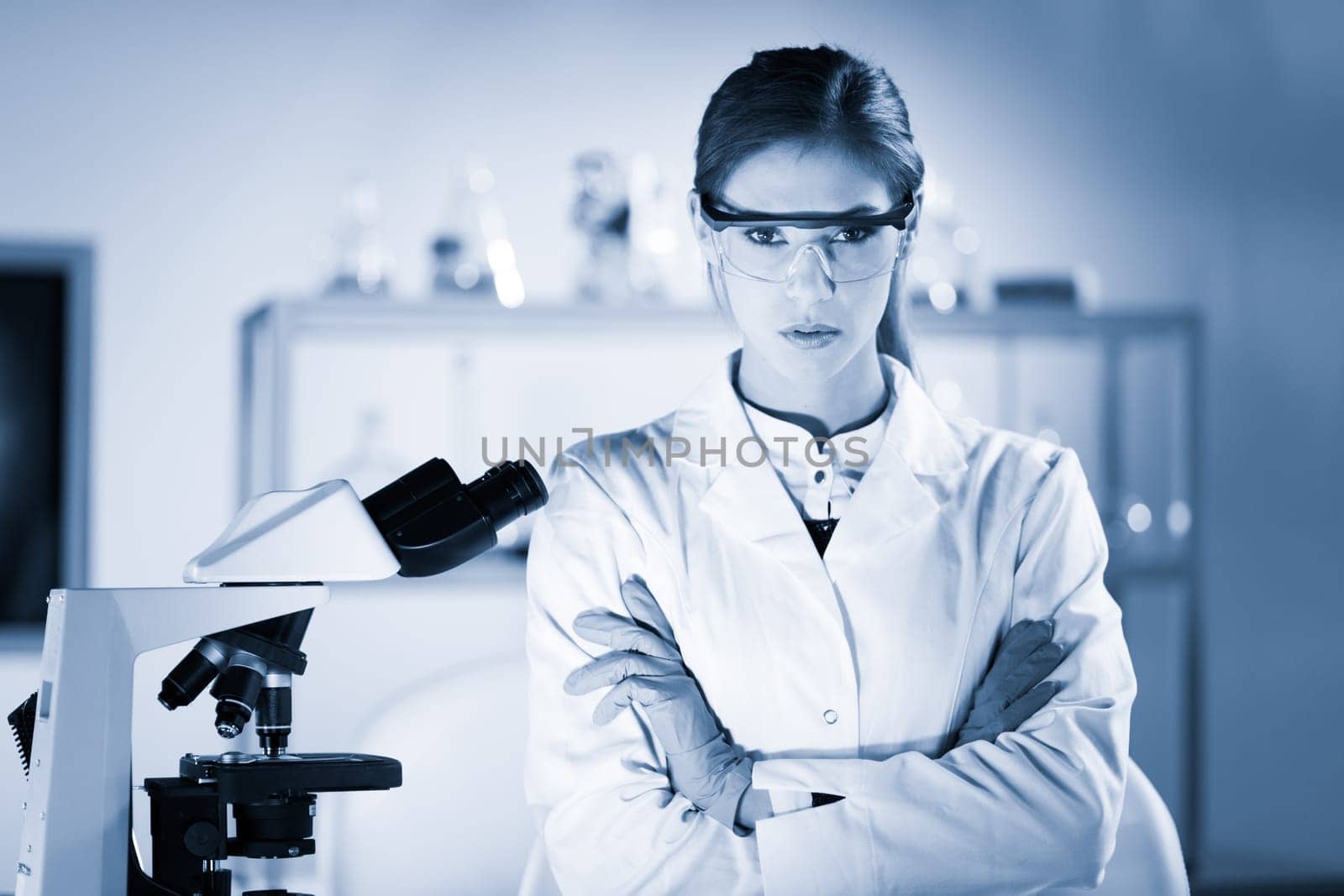 Portrait of a attractive, young, confident female health care professional in hes working environment. Blue toned black and white image.