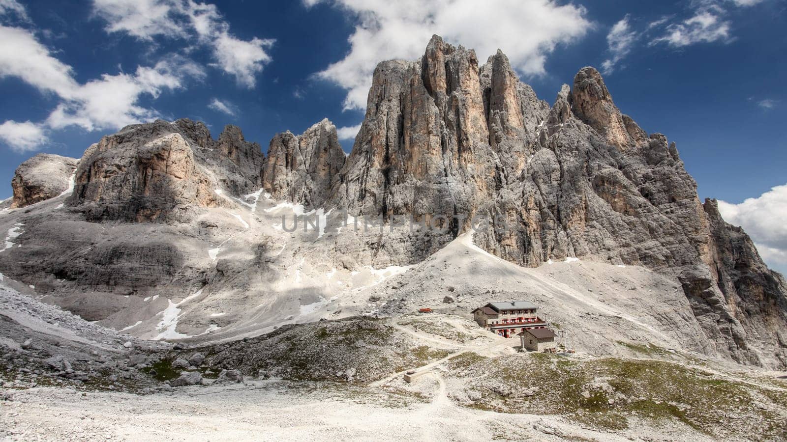 High rocky peaks of Pale di San Martino in Italian Dolomites with dramatic deep blue sky on sunny day.