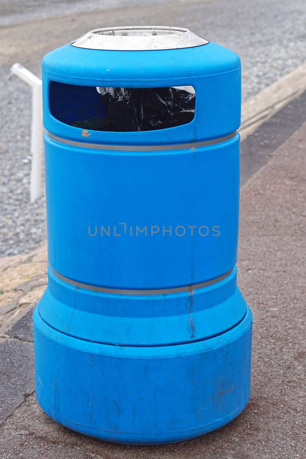 Blue plastic trash bin at street