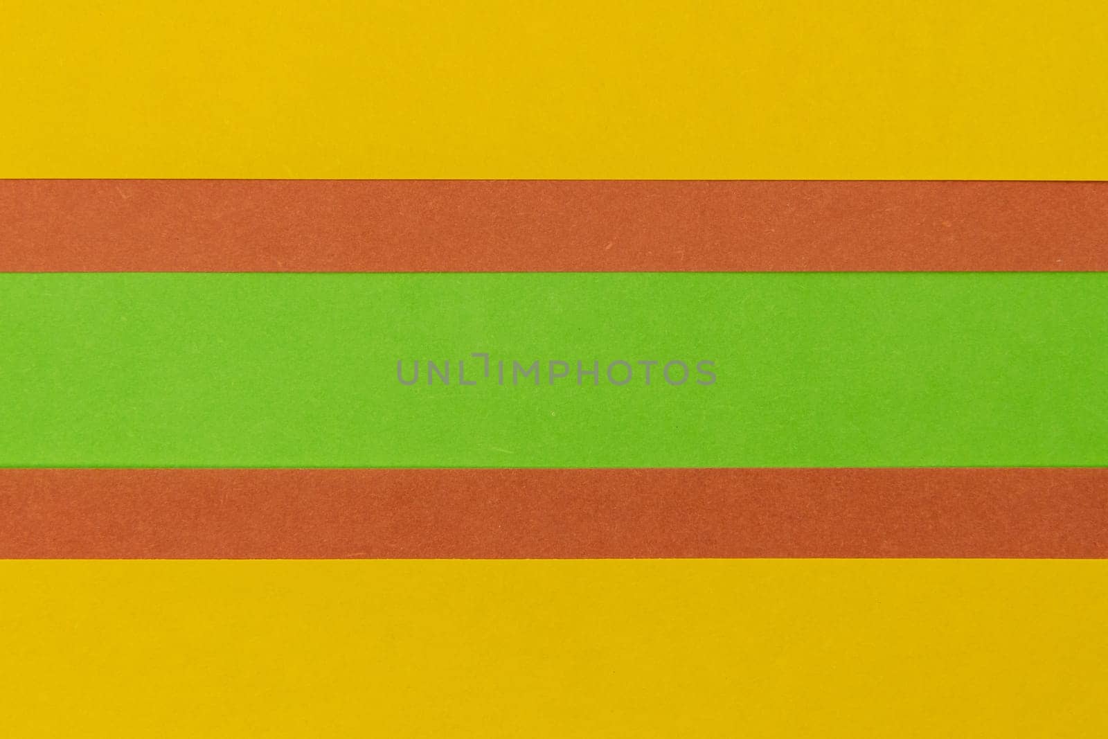 Green, Orange and Yellow coloured paper background, abstract contrast conceptual image