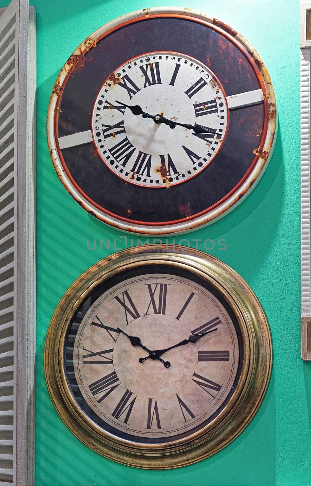 Two big vintage round clock at green wall