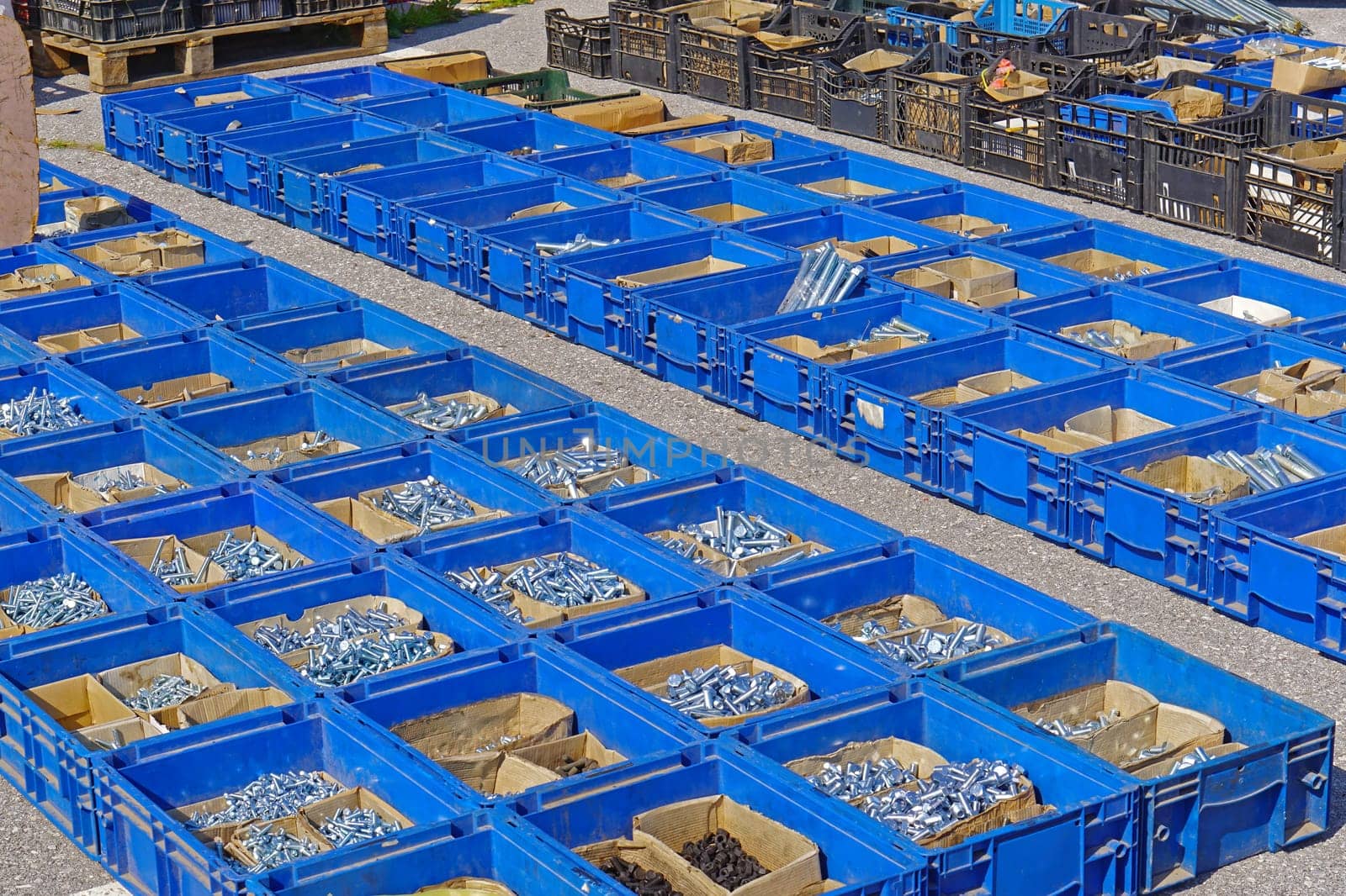 Many nuts and bolts in blue crates