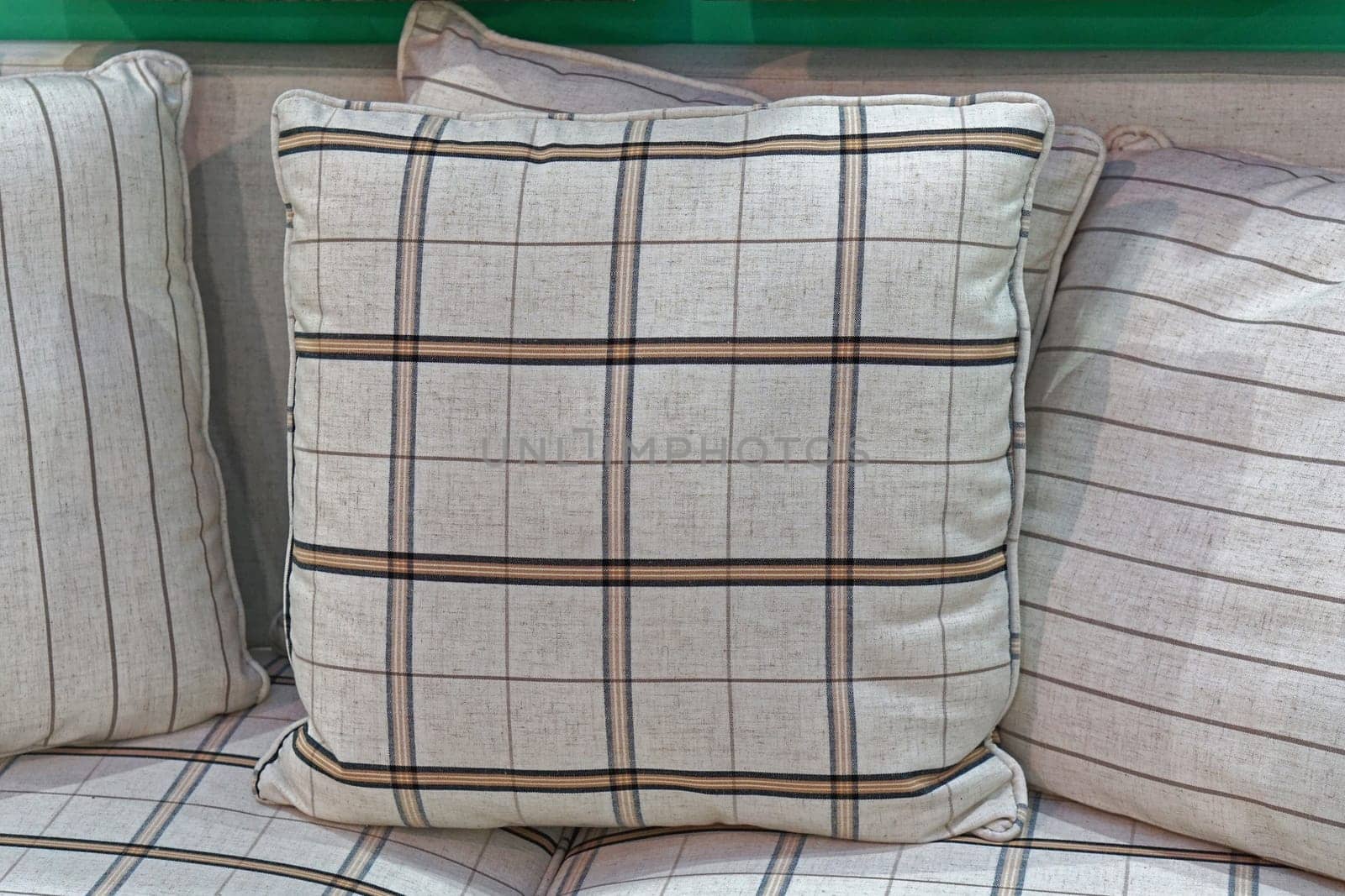 Decorative plaid textile pillows at sofa