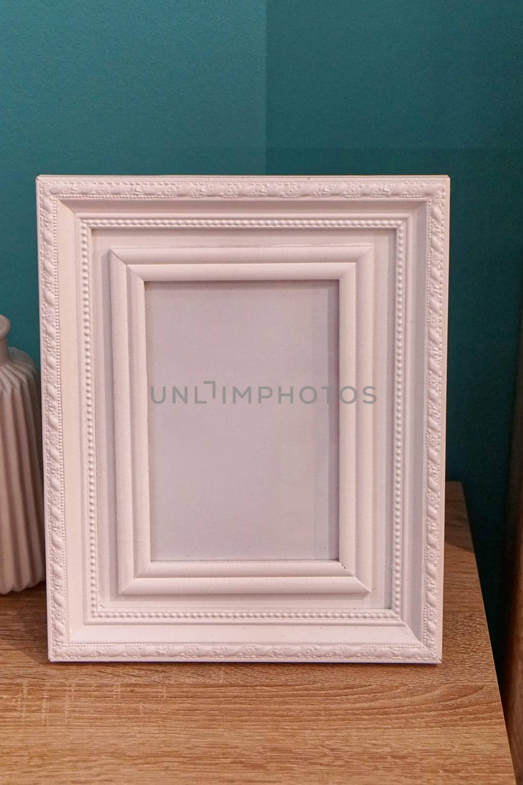 White portrait picture frame at night table