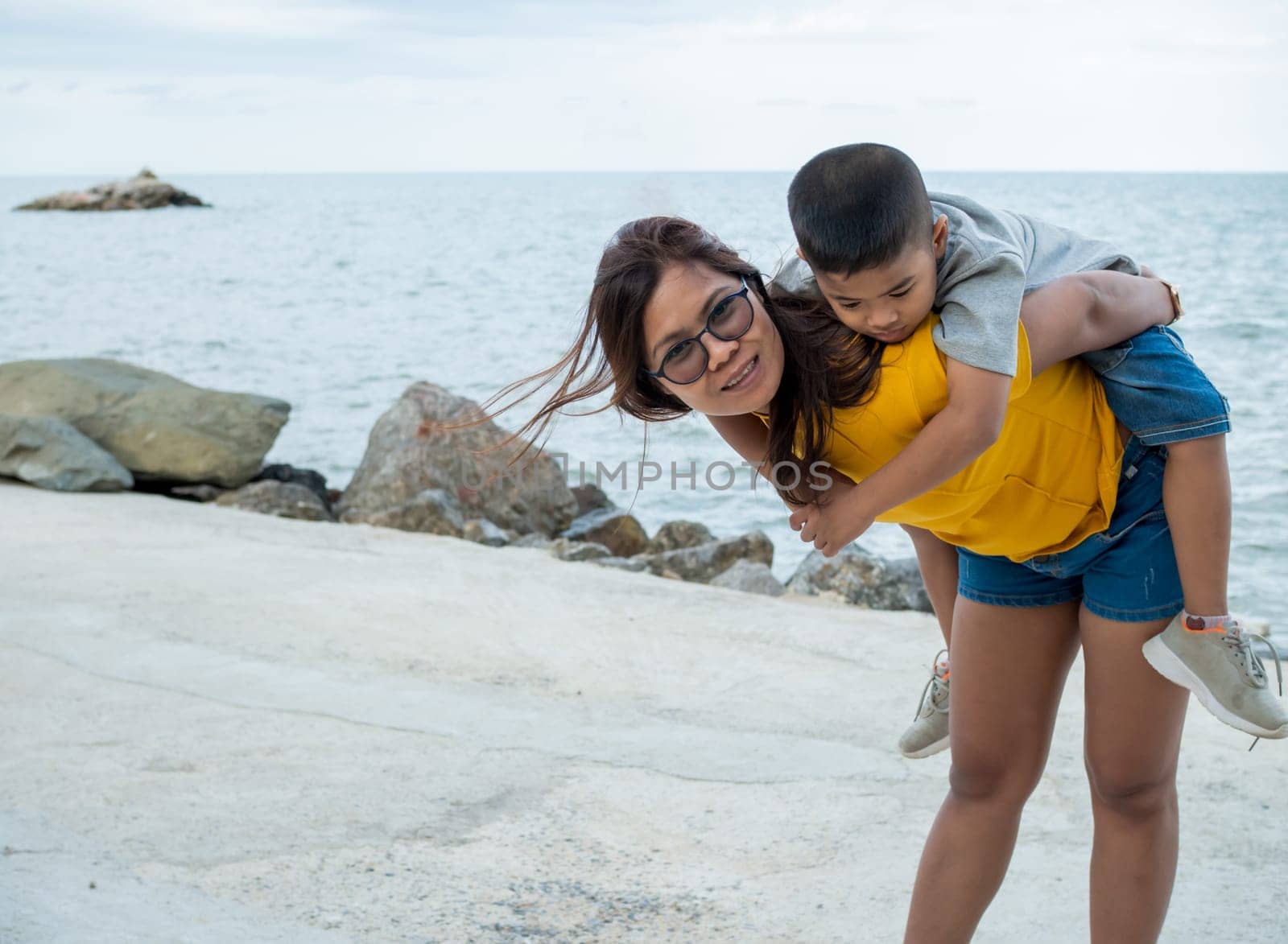 Portrait of mother and son on a sea background.