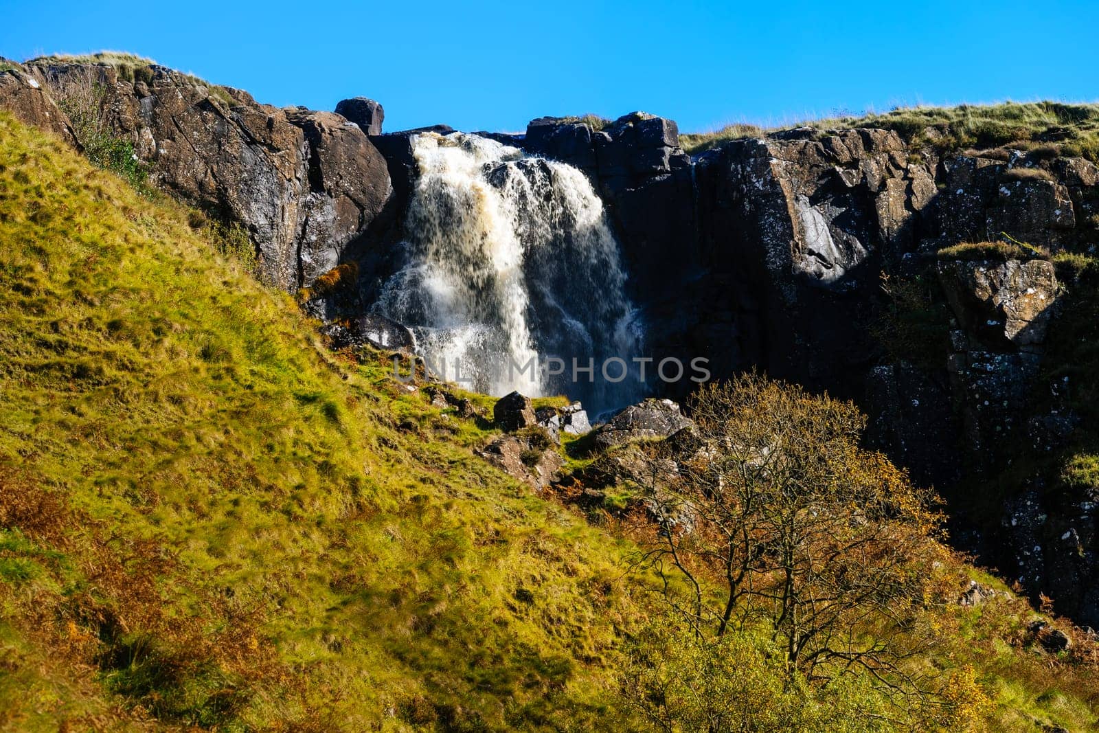 Beautiful waterfall and stream in the valley of Glenariff Forest Park in autumn colours, Count Antrim, Northern Ireland