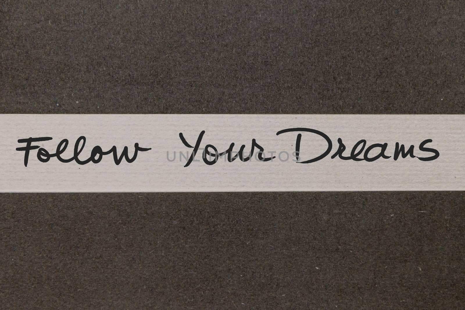 White and Grey coloured paper background with Follow Your Dreams motivational handwritten message