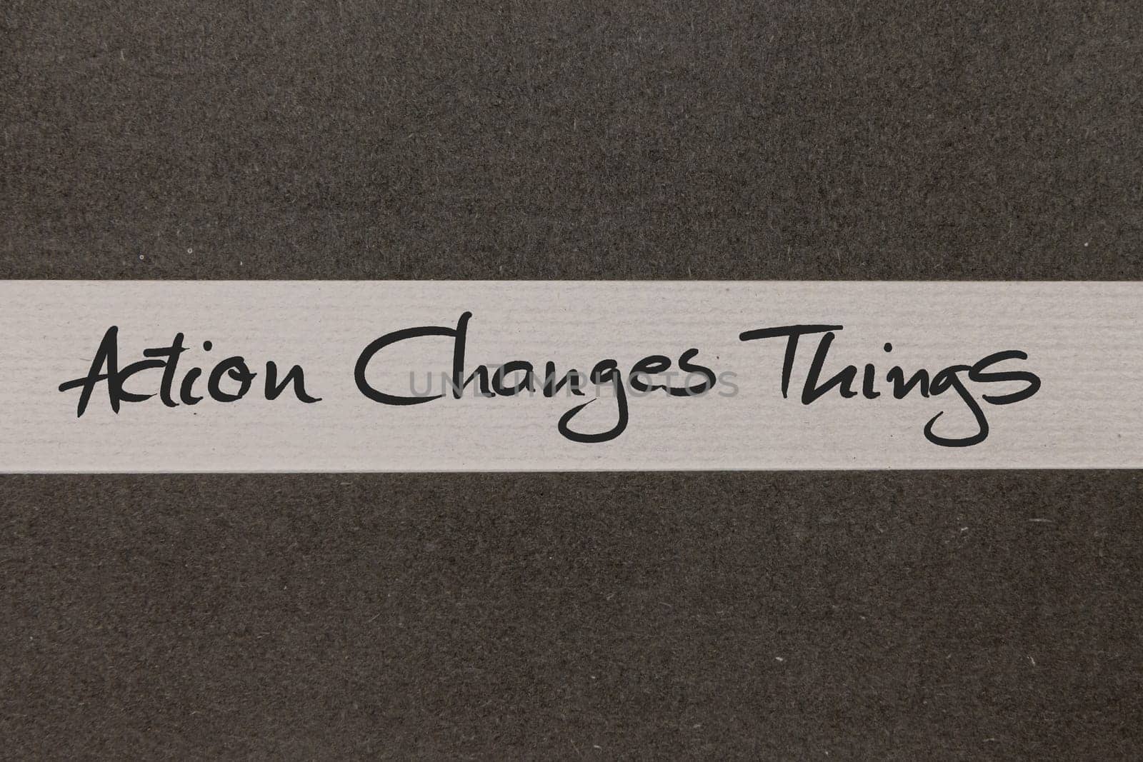 White and Grey coloured paper background with Action Changes Things motivational handwritten message