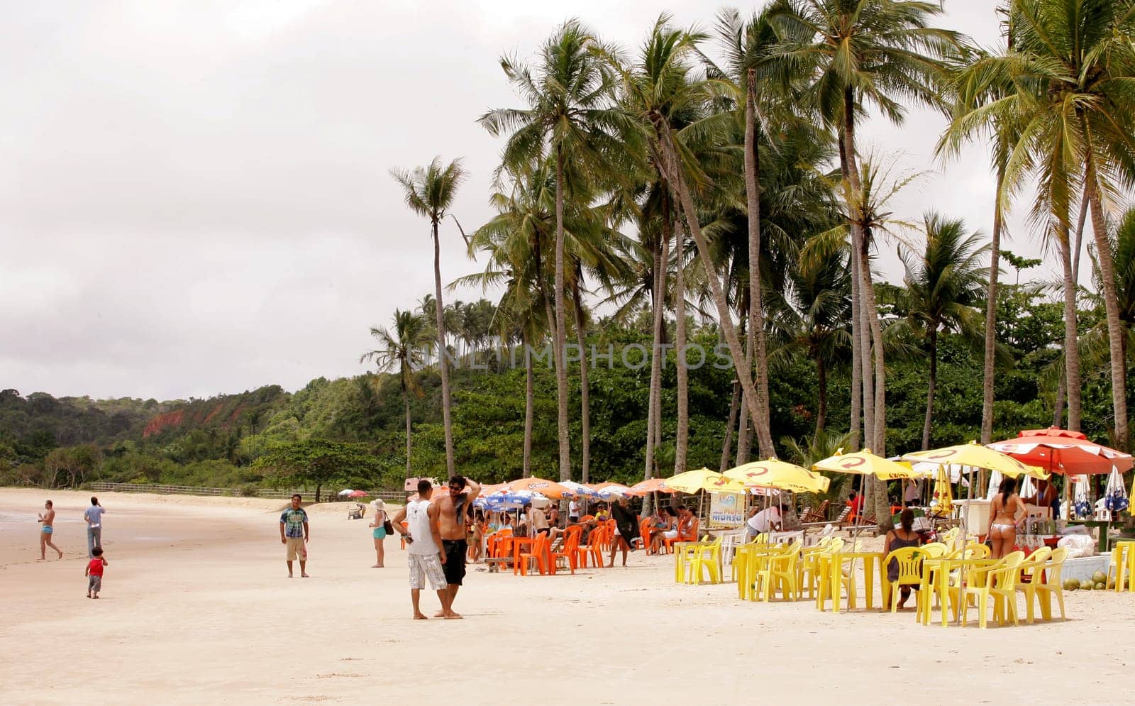 porto Seguro, bahia / brazil - january 7, 2011: people are seen sitting next to chairs on the beach of Trancoso in the city of Porto Seguro, in the south of Bahia.