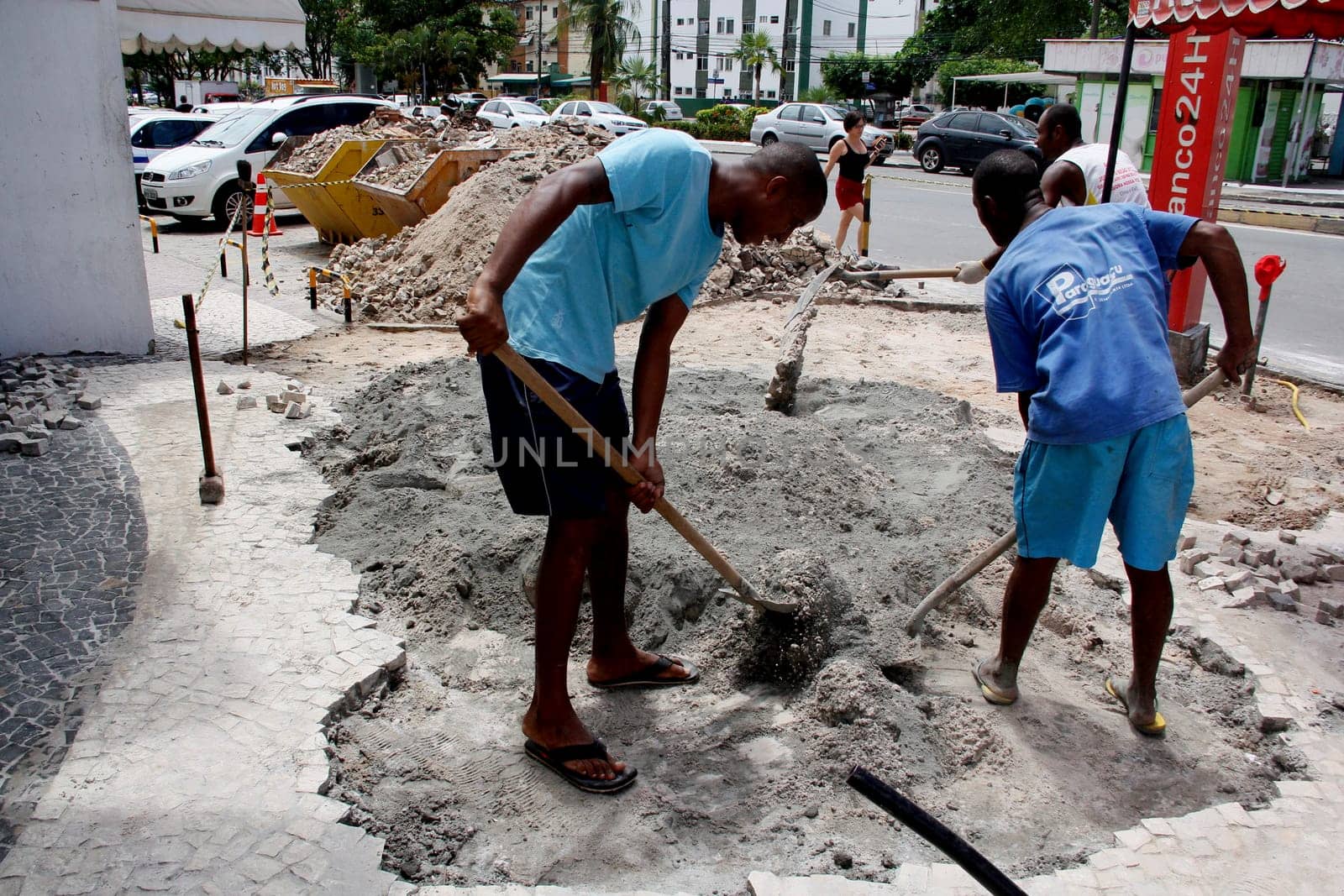 salvador, bahia / brazil - april 3, 2014: people are seen working to repair damaged sidewalk in the pituba neighborhood in the city of Salvador.