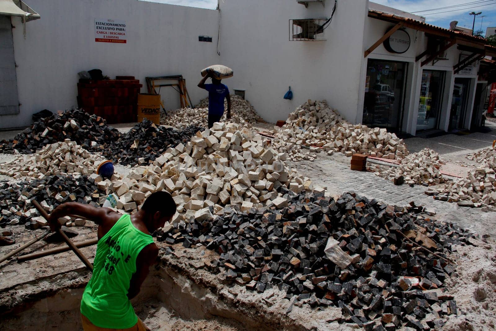salvador, bahia / brazil - april 3, 2014: people are seen working to repair damaged sidewalk in the pituba neighborhood in the city of Salvador.