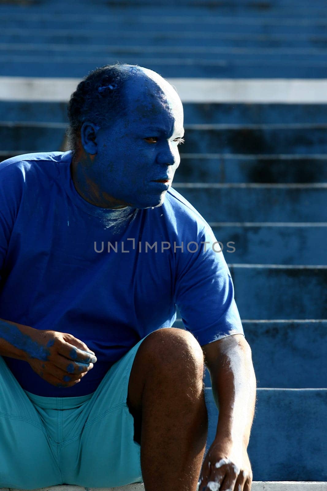 itabuna, bahia / brazil - june 11, 2011: a soccer fan paints his face with the colors of his best friend in the city of Itabuna.