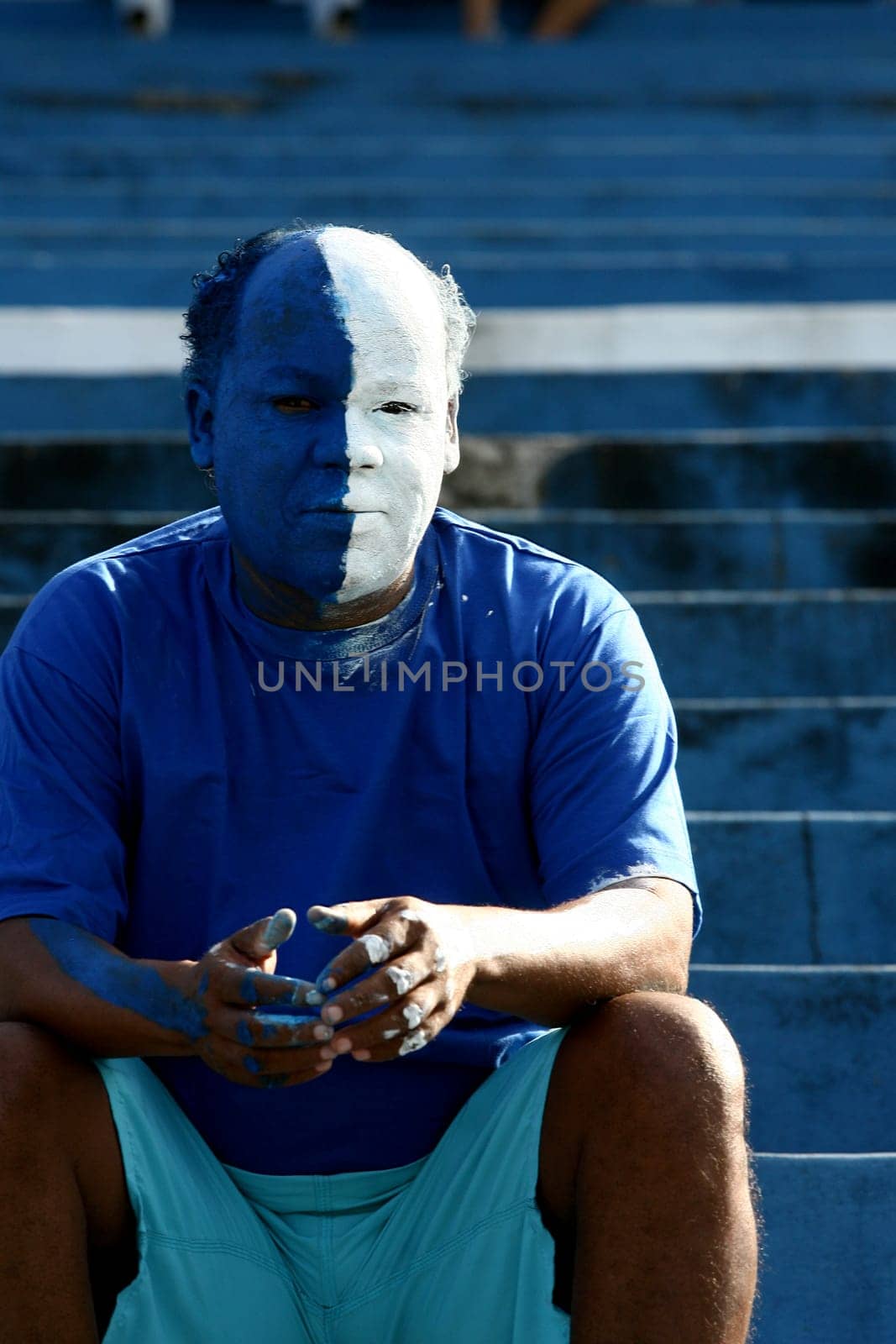 itabuna, bahia / brazil - june 11, 2011: a soccer fan paints his face with the colors of his best friend in the city of Itabuna.