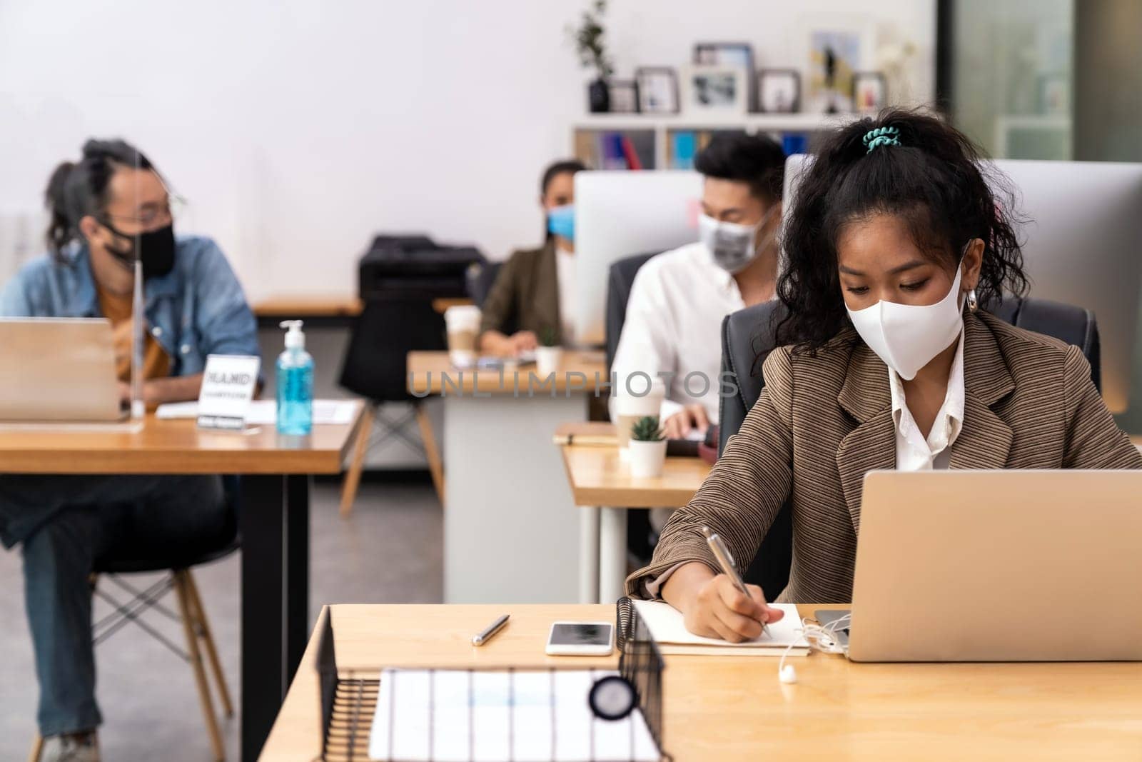 Mixed race of African black and asian business woman wear face mask working in new normal office with social distance to Group of business team people to prevent coronavirus COVID-19 spreading
