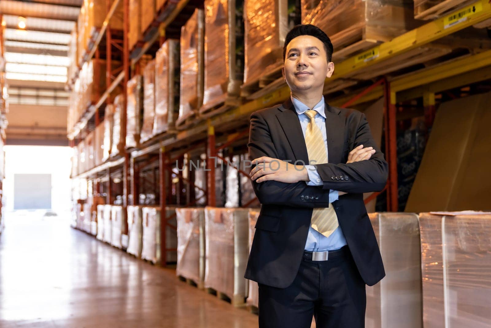 Portrait of asian confidence businessman investor stand in large factory and distribution warehouse environment. Business owner and investment concept.
