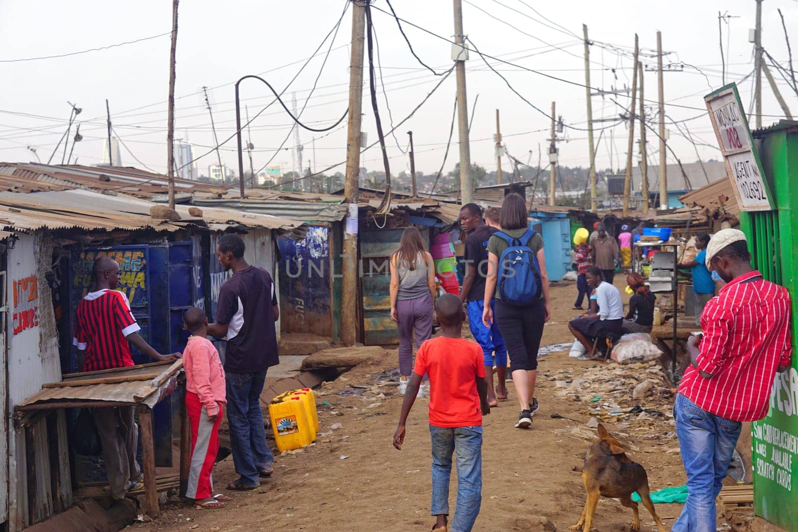 Nairobi, Kenya - July 10, 2017: Tourists and locals walking at street of Kibera slum in Nairobi, Kenya.