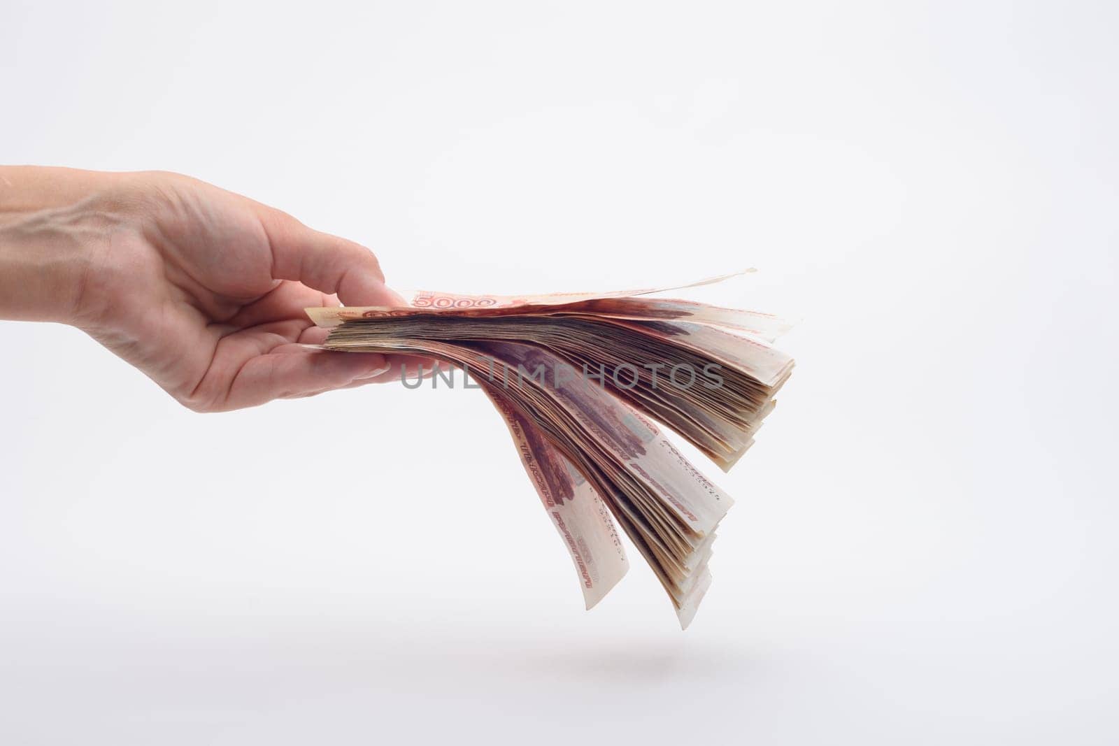 Hand holds out a wad of money, white background