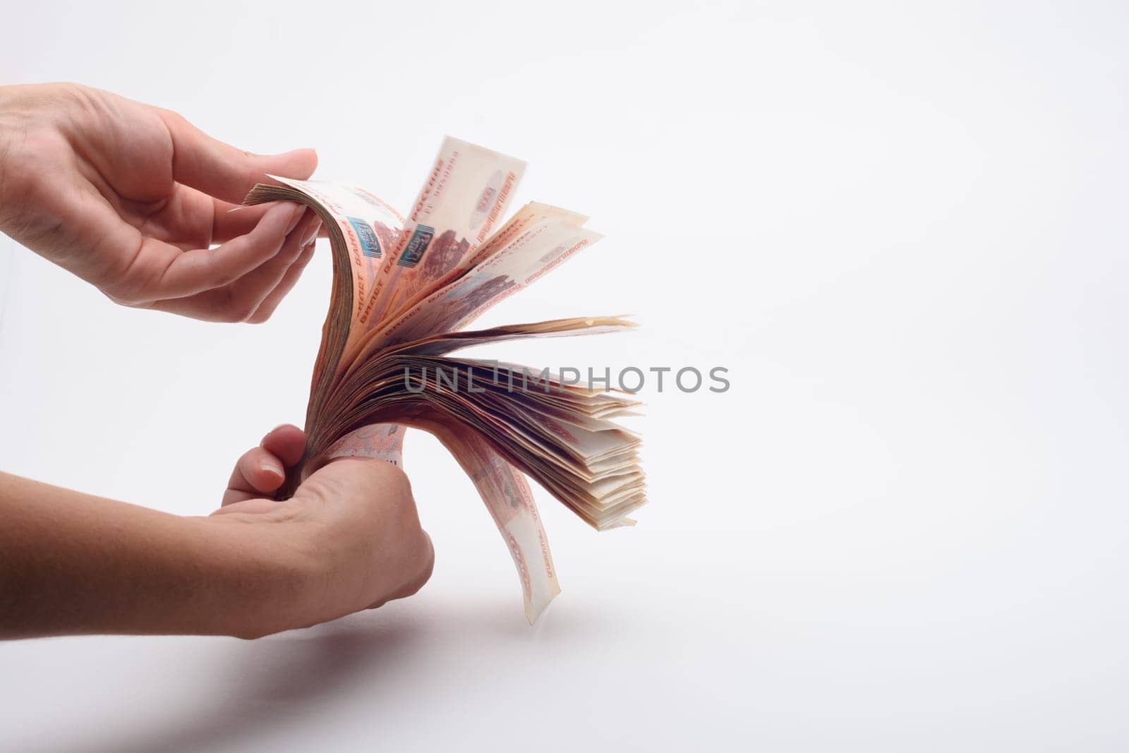 Hand fan counts a wad of money, white background