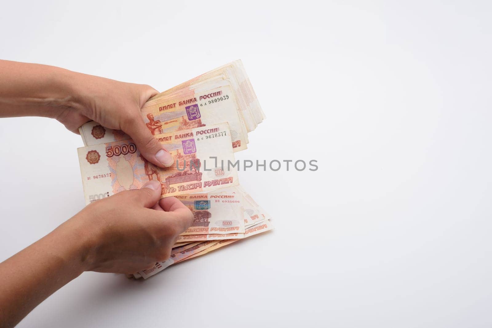 Hands count money in a bundle of five-thousandth Russian bills