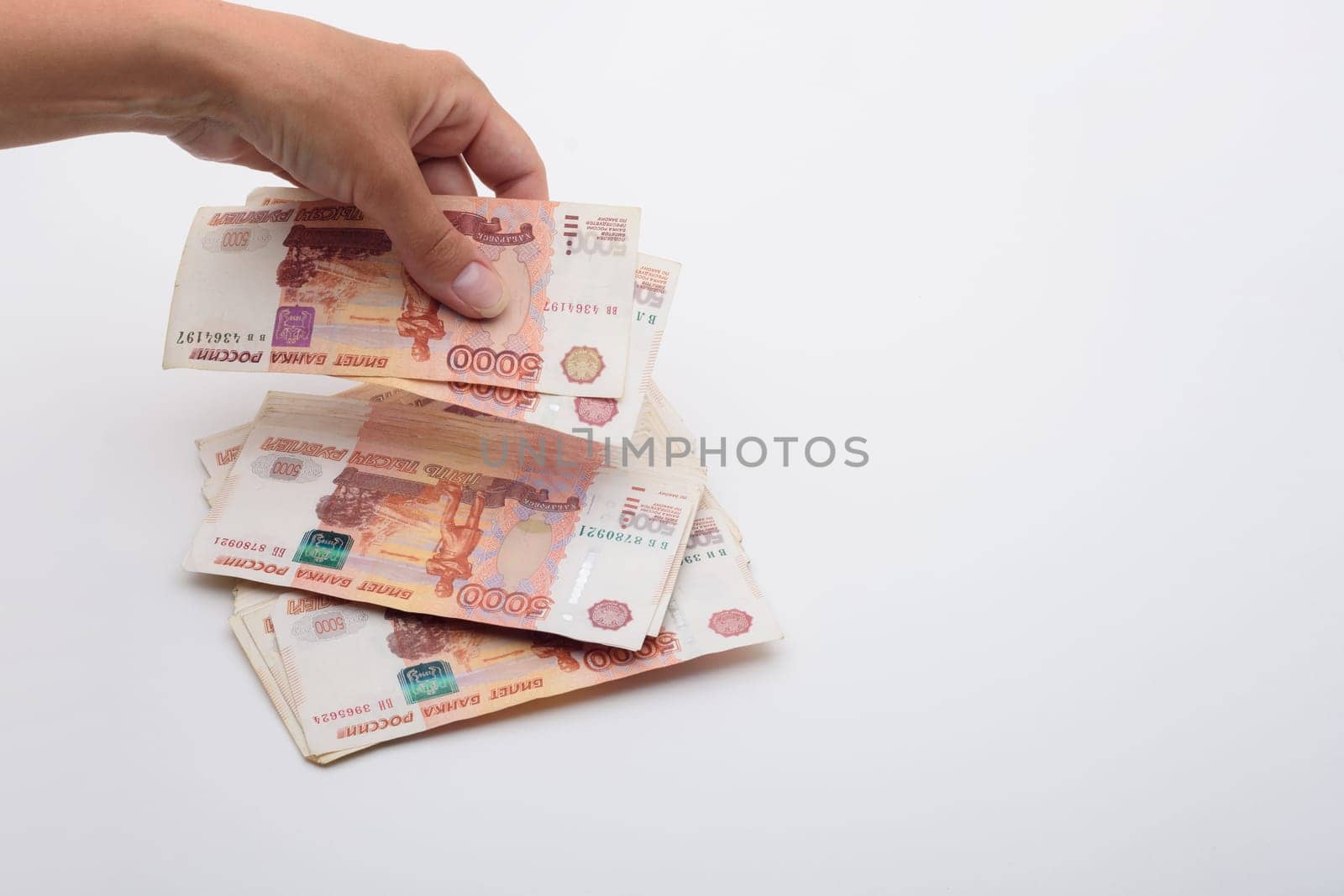 Hand throws 5000 rubles banknotes on a white background