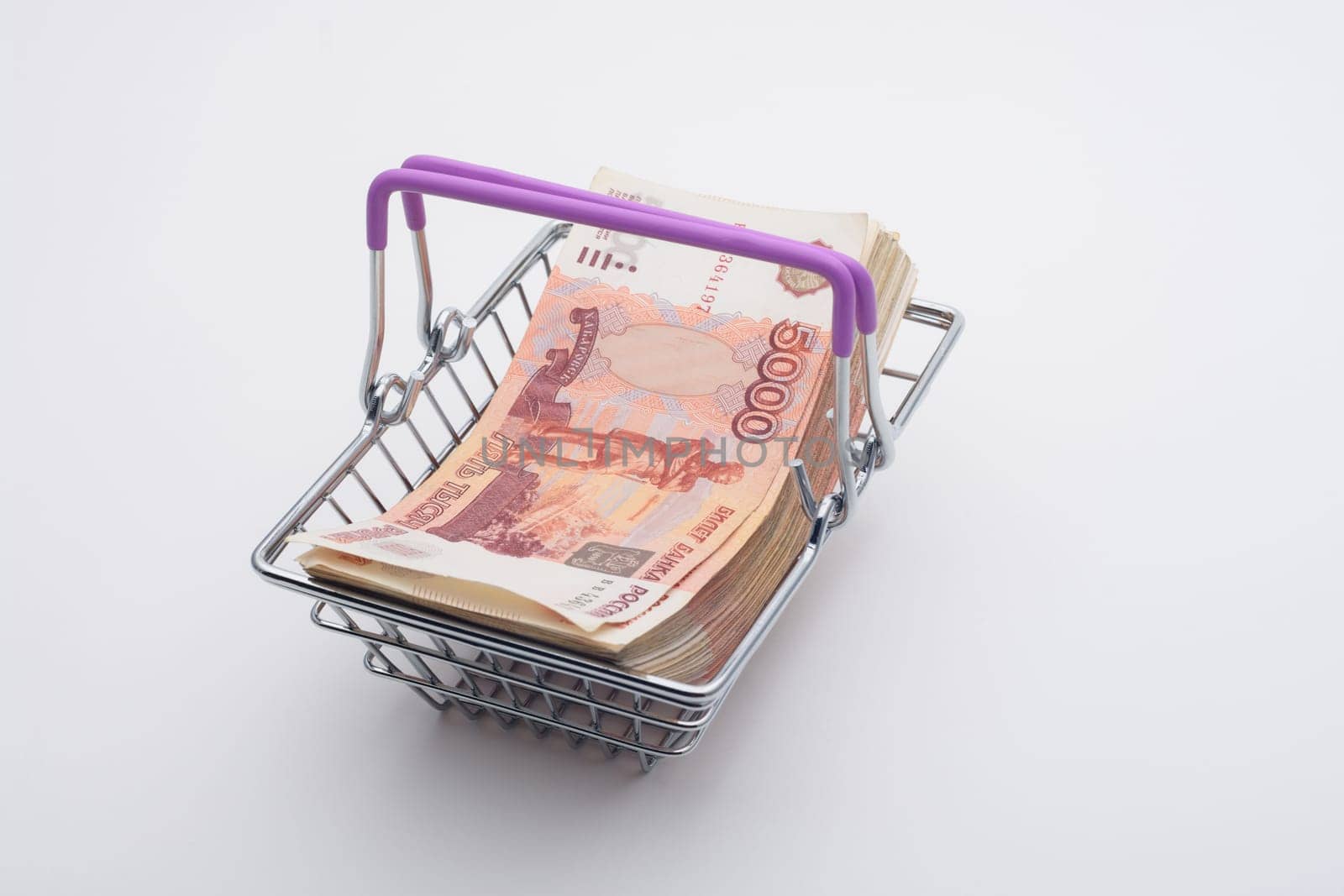 A large bundle of Russian bills is in a grocery basket, white background