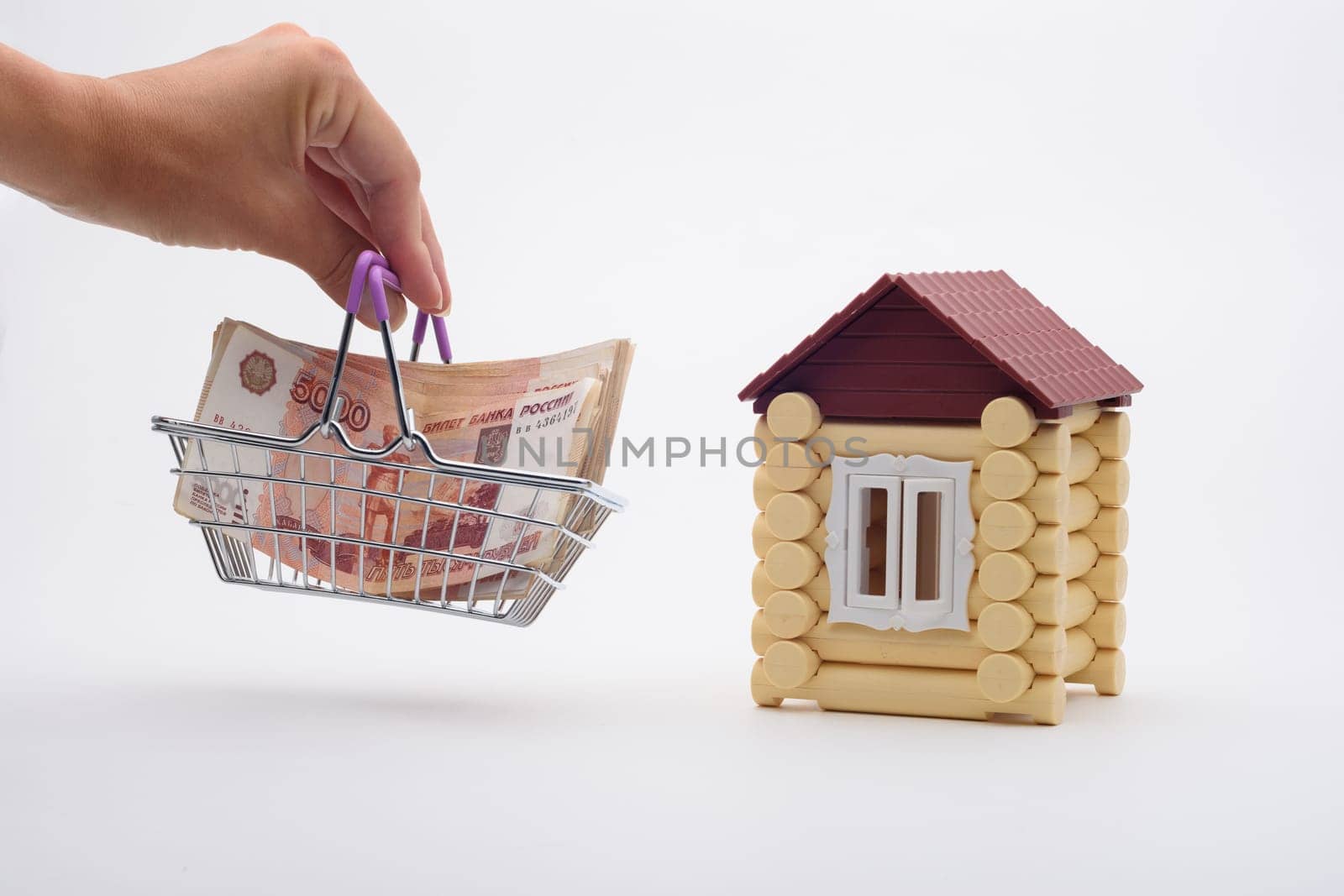A hand brings a basket with a bundle of Russian five-thousandth bills to the house