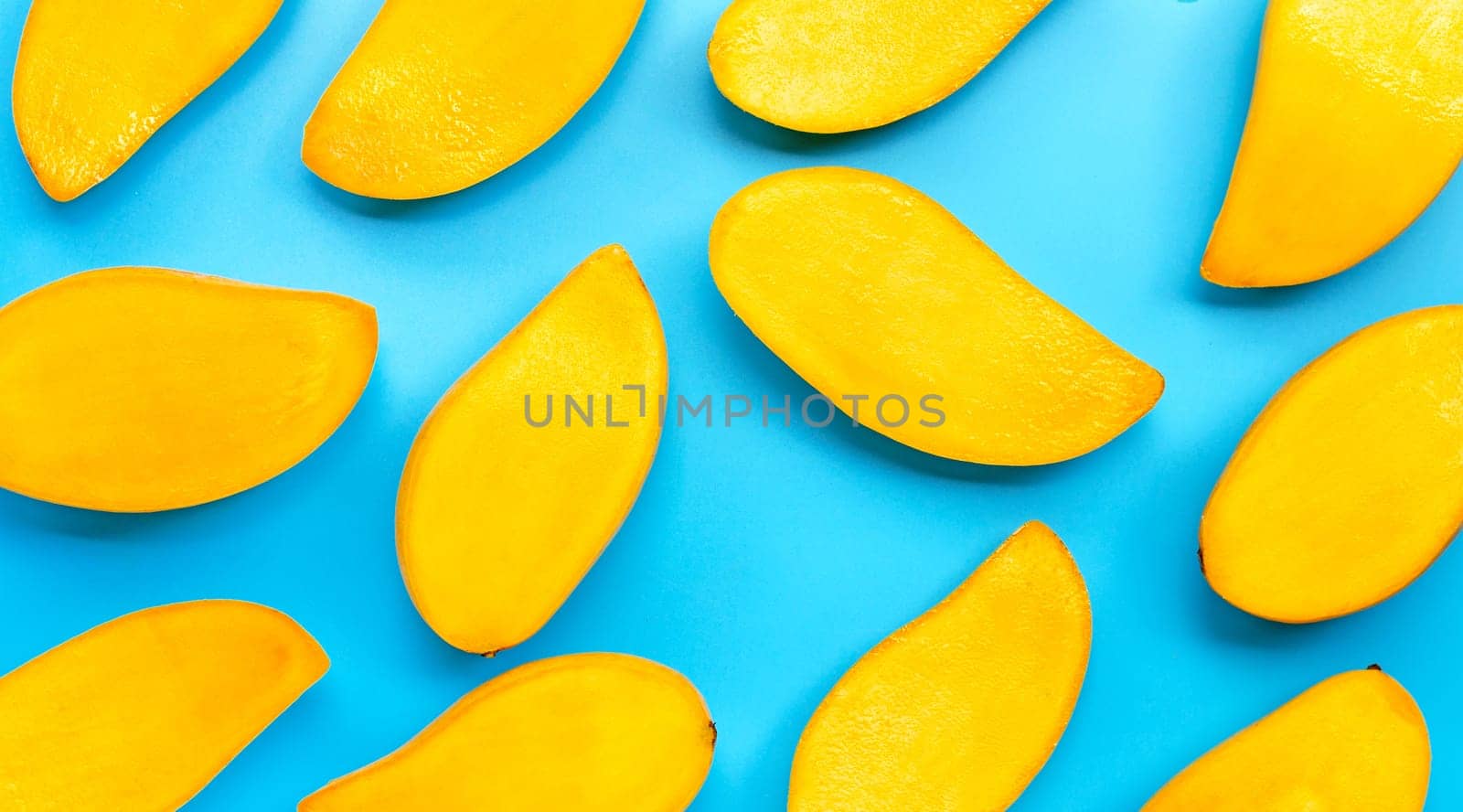 Tropical fruit, Mango slices on blue background. Top view