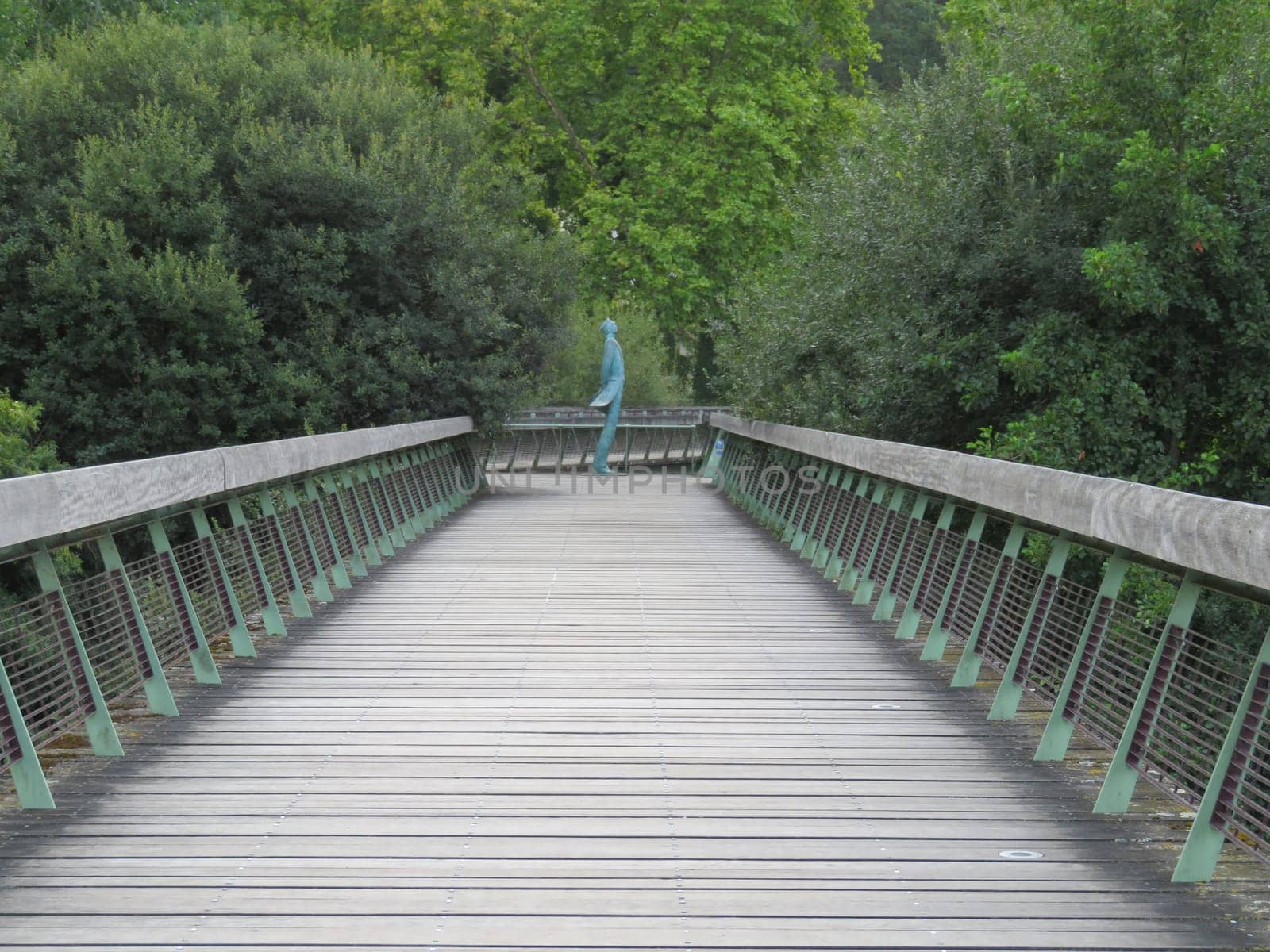 beautiful wooden walkway with an artistic figure in the background