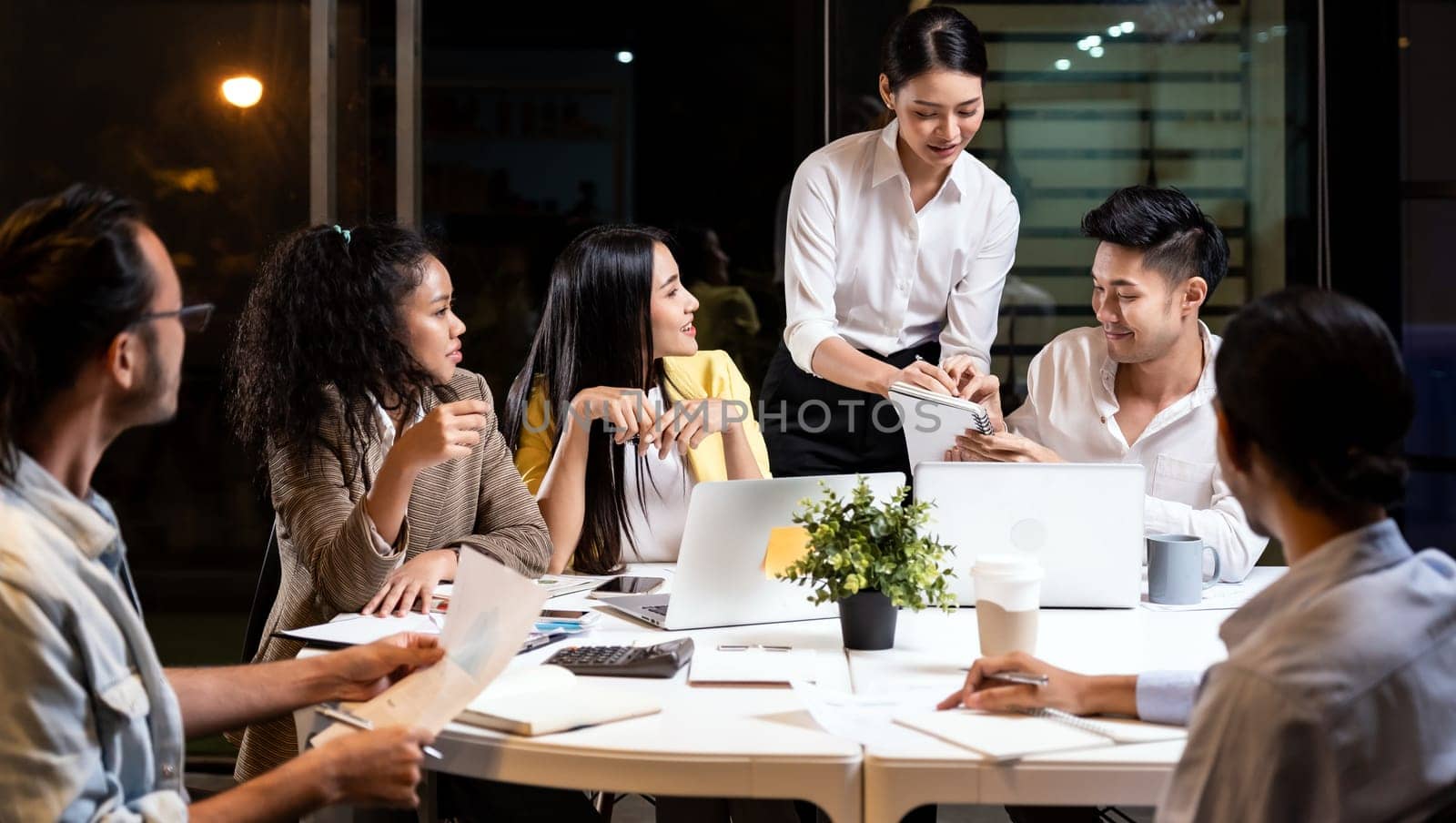 Work late concept of Interracial asian business team brainstorm idea at office meeting room at night. Work hard deadline and overtime working and new business start up concept.
