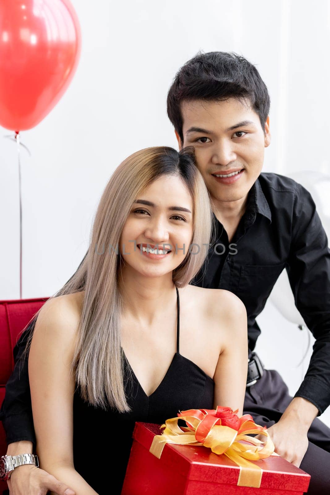 Portrait of couple holding gift box present celebrating New Year Party festival holiday in living room