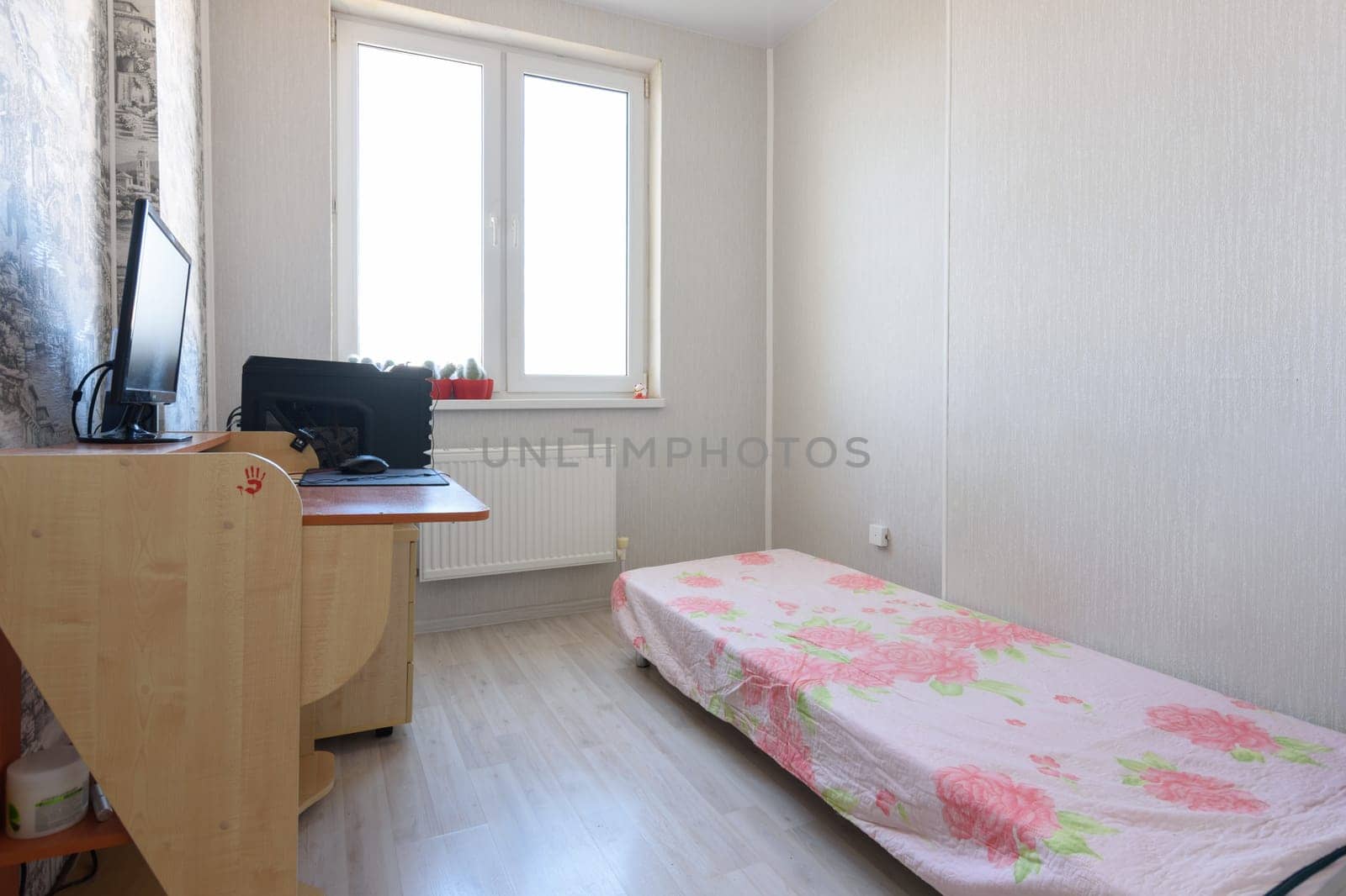 Anapa, Russia - June 22, 2020: Bachelor bedroom interior, sparse interior and computer table