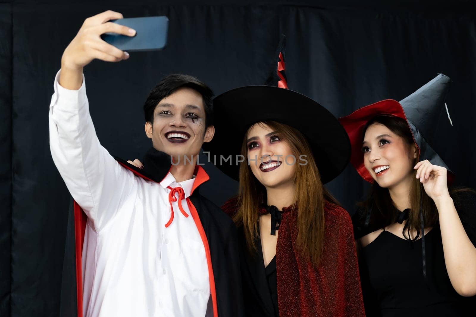 Group of friends asian young adult people celebrate a Halloween party carnival Festival. They wear Halloween costumes take selfie photographing. Halloween celebrate and international holiday concept.