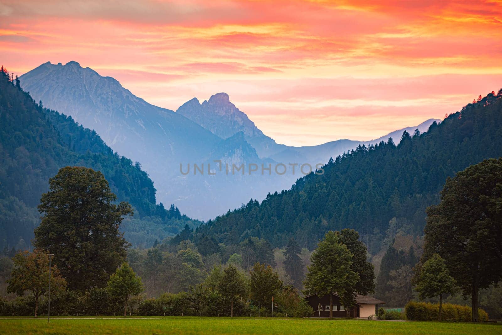 Mountains in Bavaria, Germany, Europe. Sunset scene with meadow in foreground and cloudy sky in background
