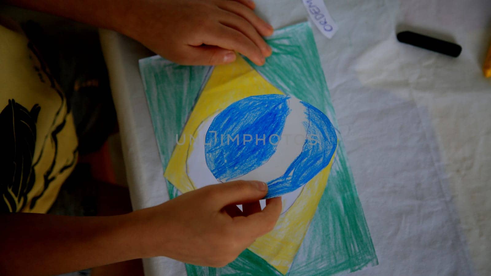 salvador, bahia / brazil - september 3, 2020: child paints brazil flag with crayons at his home in the city of Salvador.