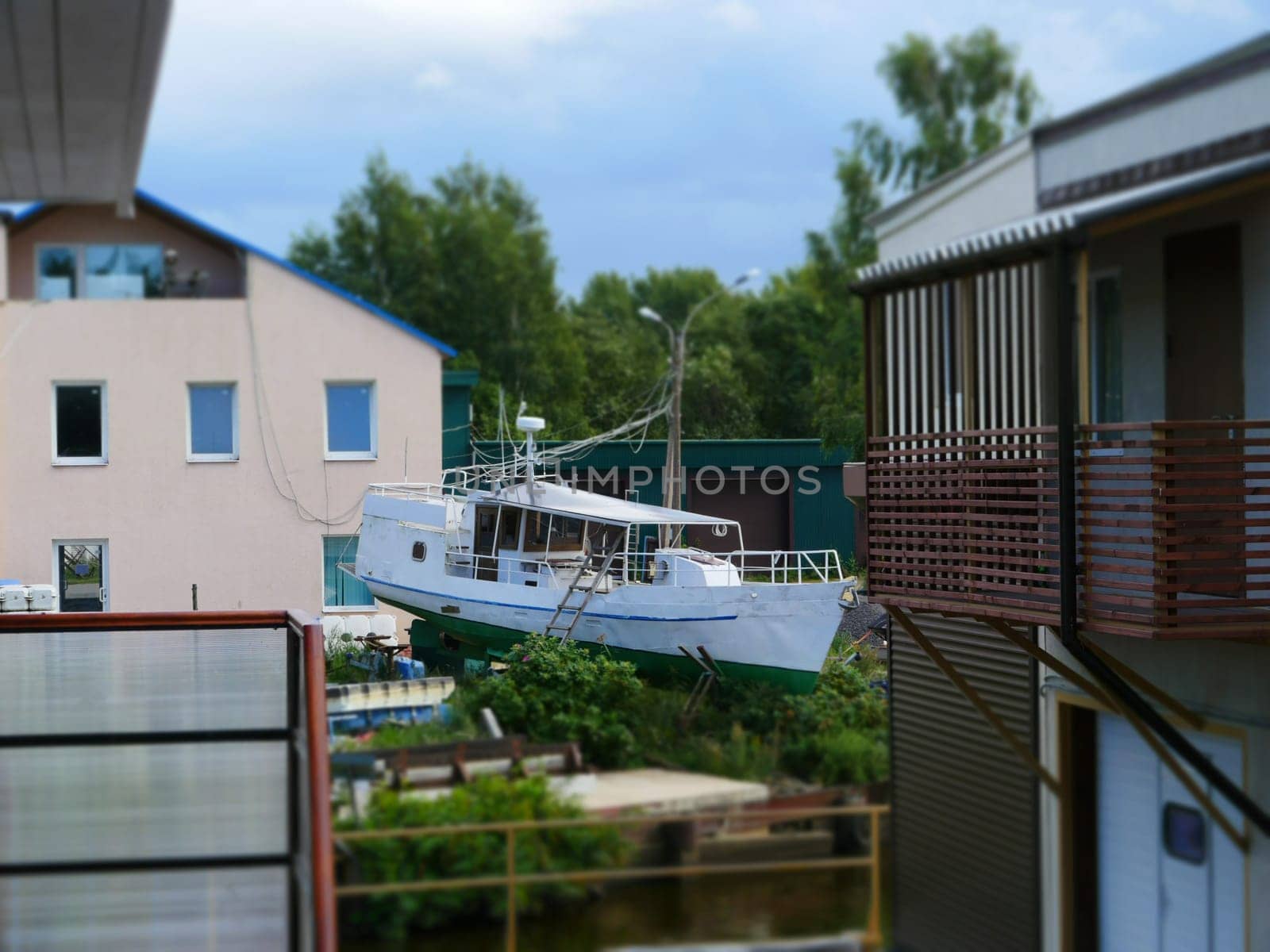 fishing boat on the shore among houses, rural landscape tilt film