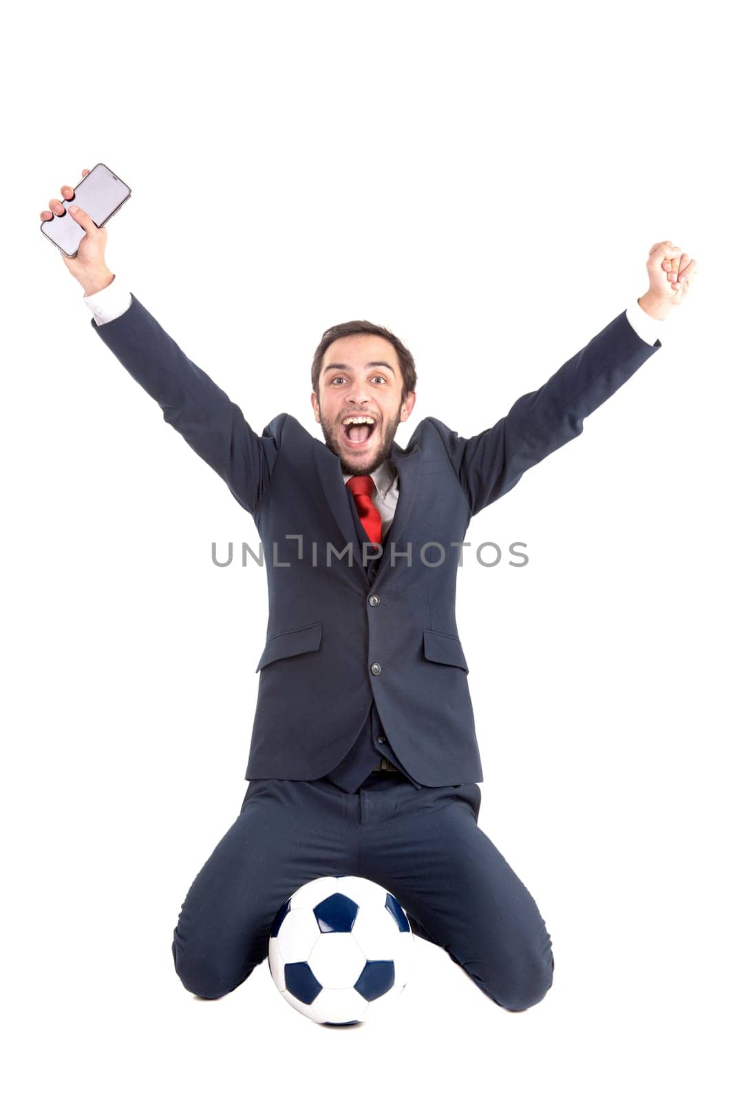 Happy businessman with soccer ball and phone posing isolated in white
