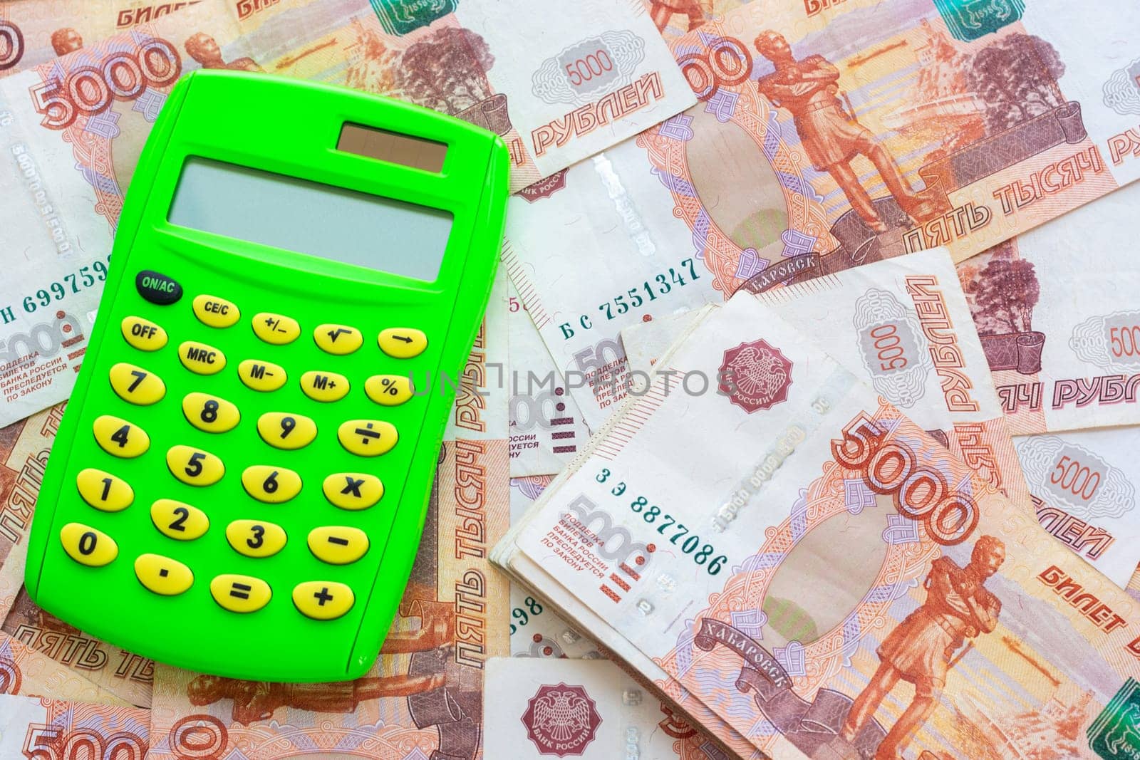 Green calculator and a bunch of five thousandth bills