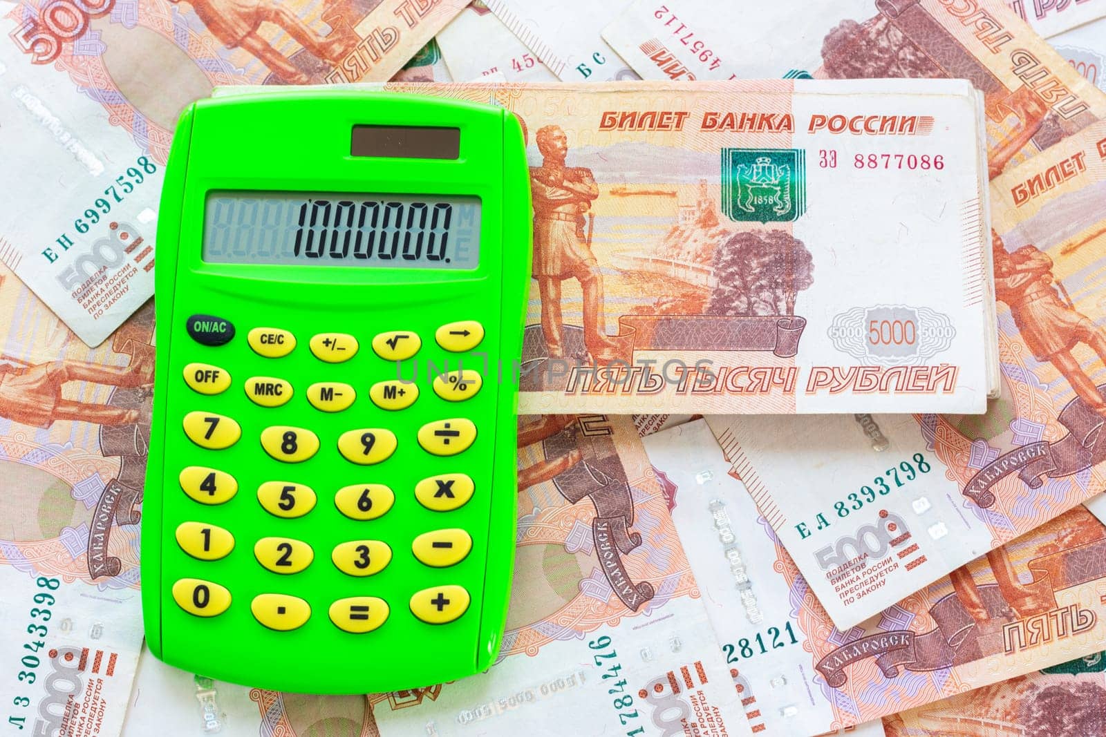 The number 1,000,000 is written on the calculator, the calculator lies on a pile of money