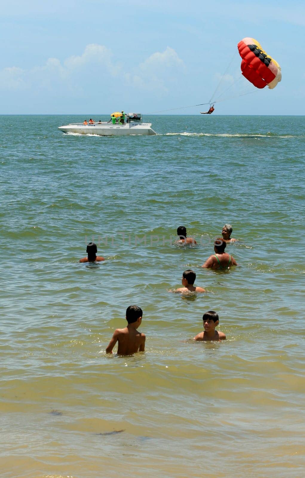 porto seguro, bahia / brasil - 8 de janeiro de 2009: pessoa é vista utilizando parasail - paraquedas puxado por barco - na praia da cidade de Porto Seguro..