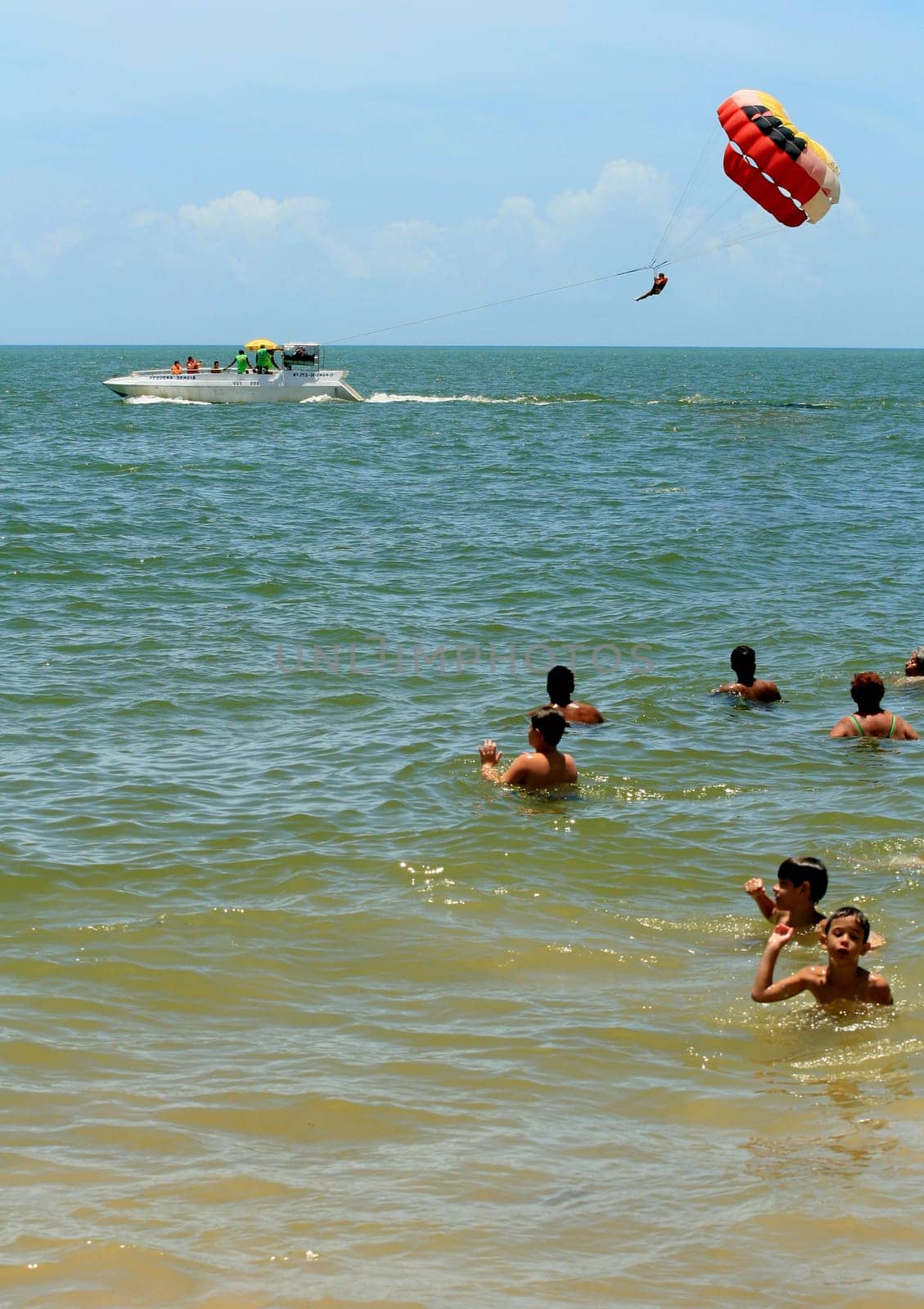 porto seguro, bahia / brasil - 8 de janeiro de 2009: pessoa é vista utilizando parasail - paraquedas puxado por barco - na praia da cidade de Porto Seguro..