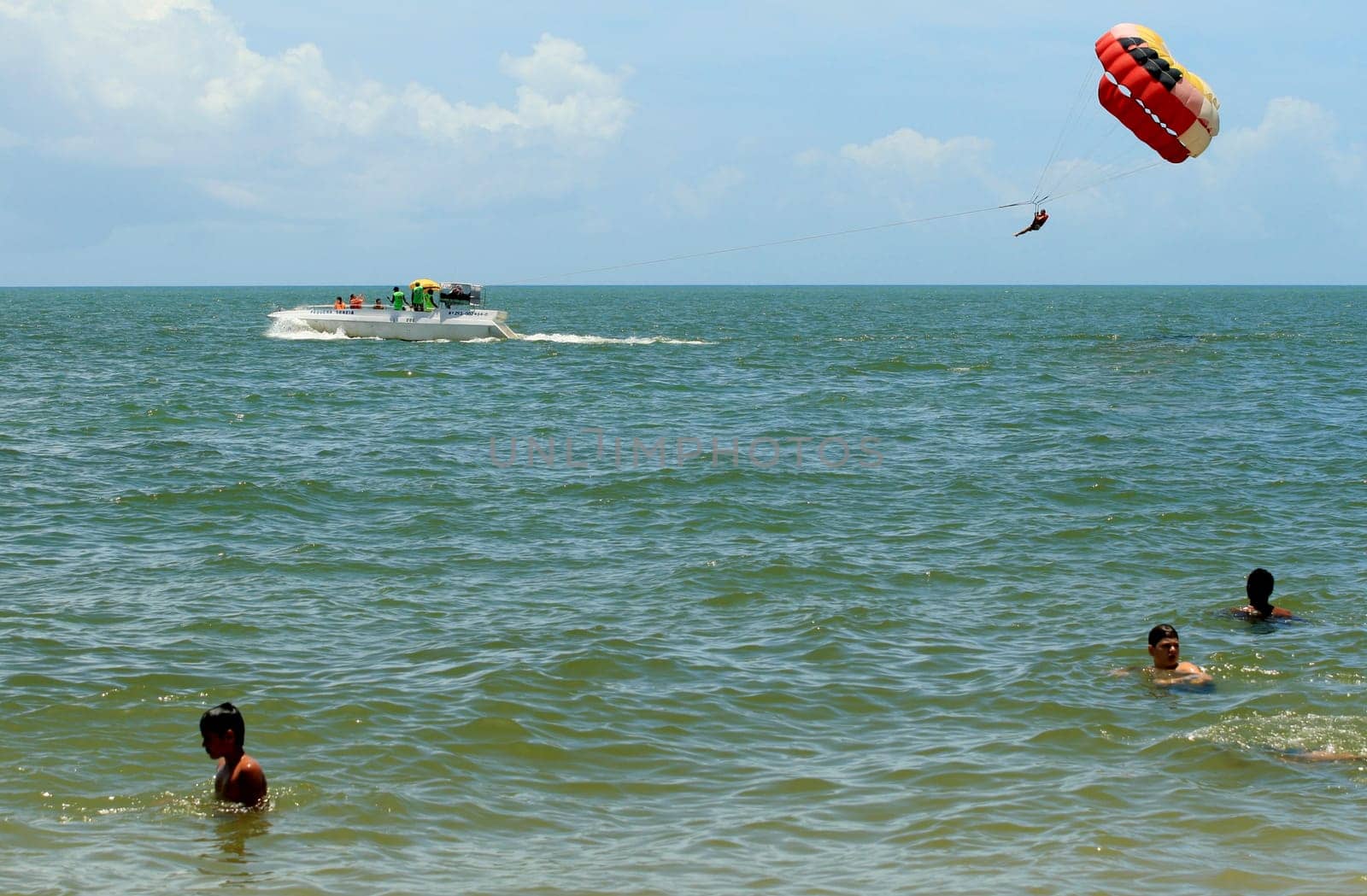 porto seguro, bahia / brasil - 8 de janeiro de 2009: pessoa é vista utilizando parasail - paraquedas puxado por barco - na praia da cidade de Porto Seguro..